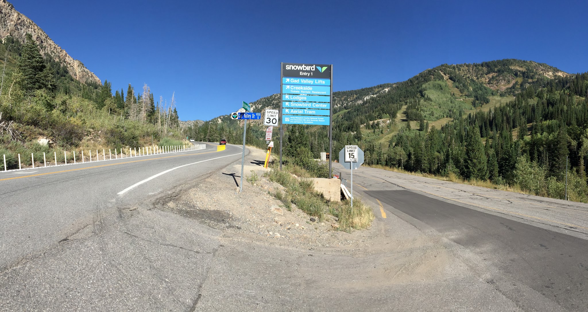 Cyclist with bike at top of Little Cottonwood Canyon climb by bike.