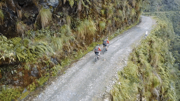 Death Road - Postcard Corner 2 cyclists sitting on cliff on Death Road Bolivia Postcard Corner
