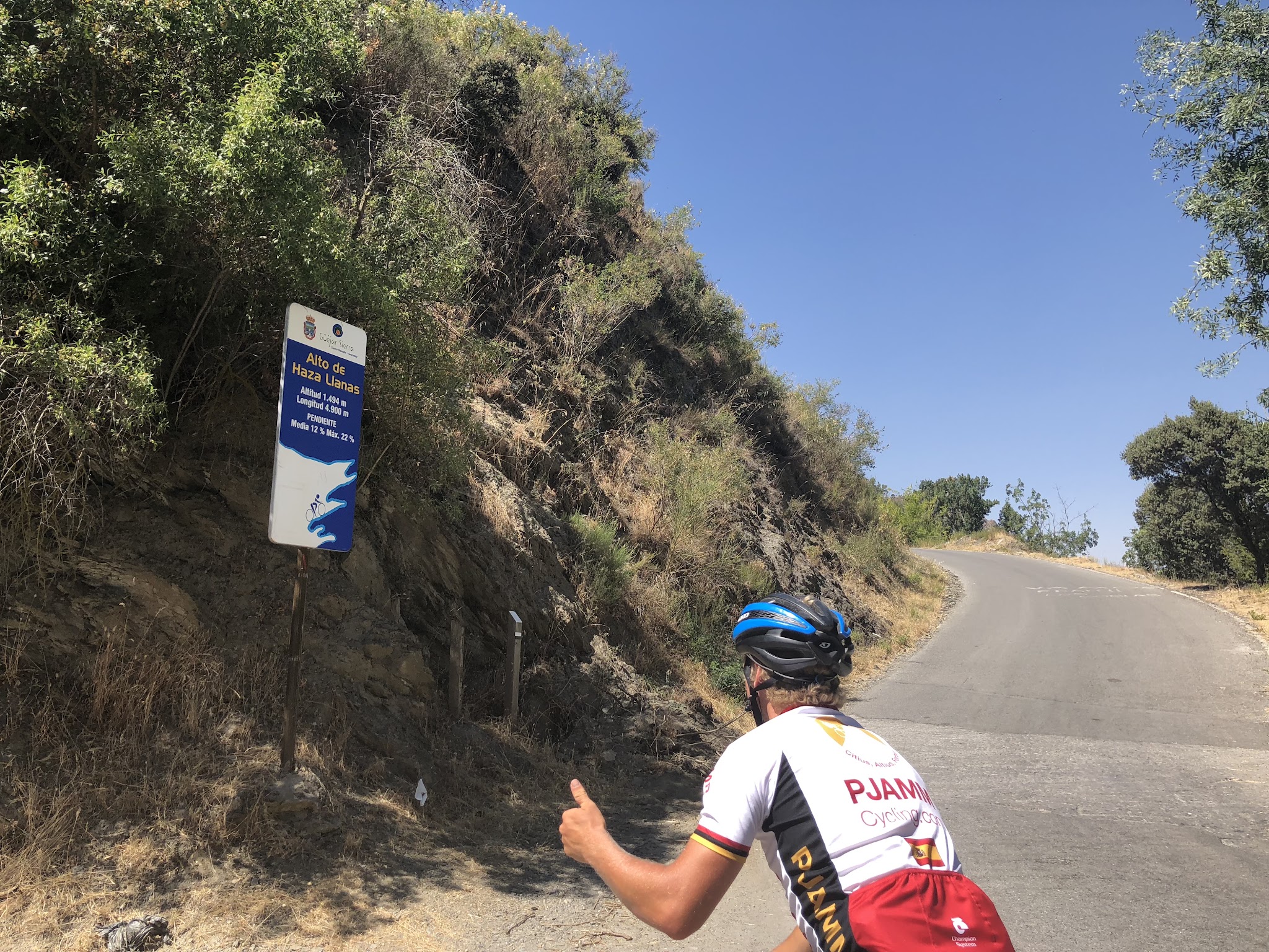 Road sign and bicyclist at start of Pico de Veleta road bike climb