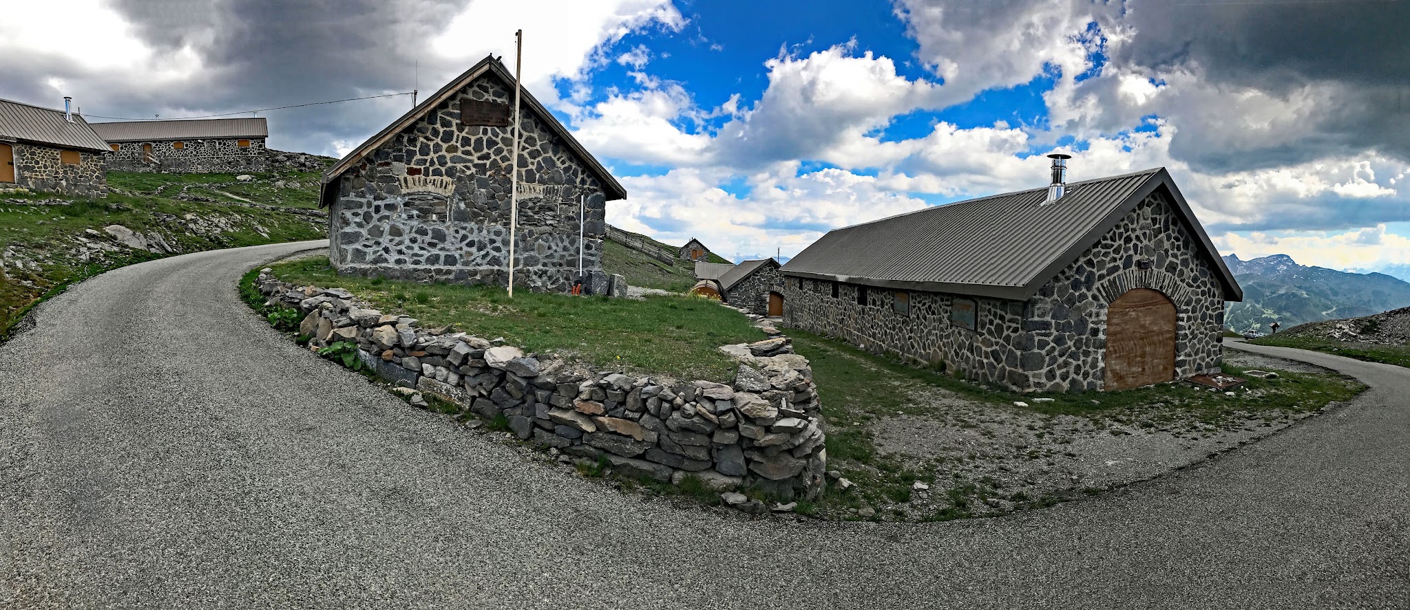 Cycling Col du Granon  - beautiful old stone buildings along switchback in roadside shortly before climb finish
