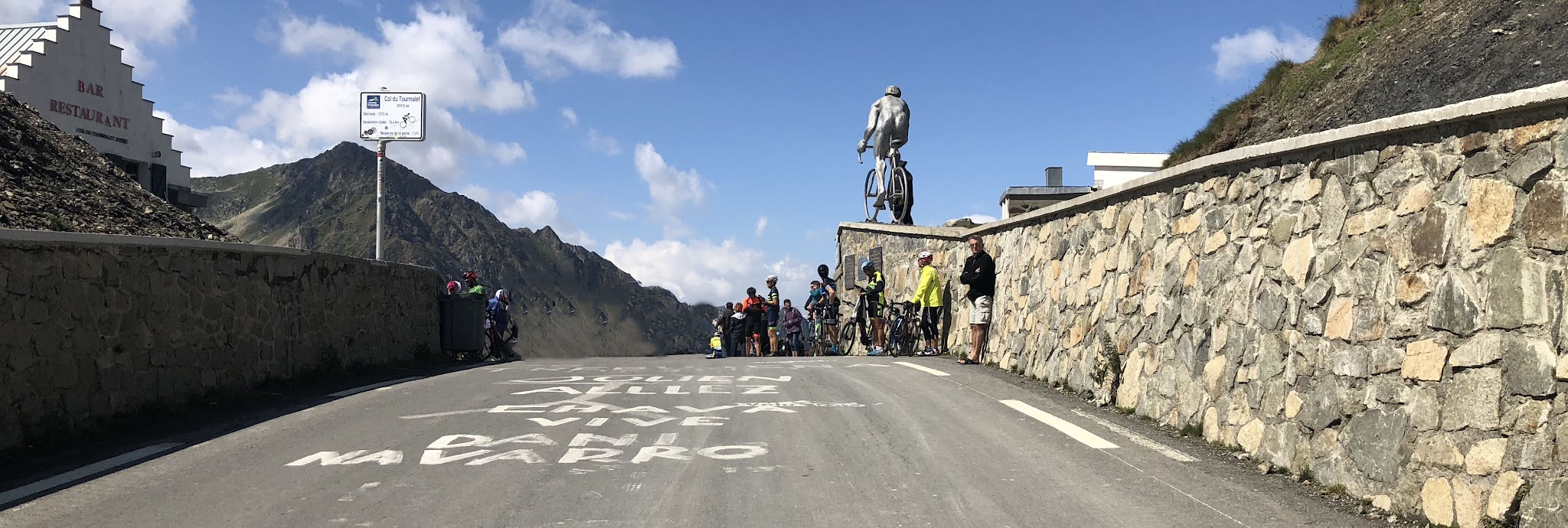 Climbing Col du Tourmalet by bike - drone aerial photo of col - cyclists, restaurant, statue, Le Géant, col sign