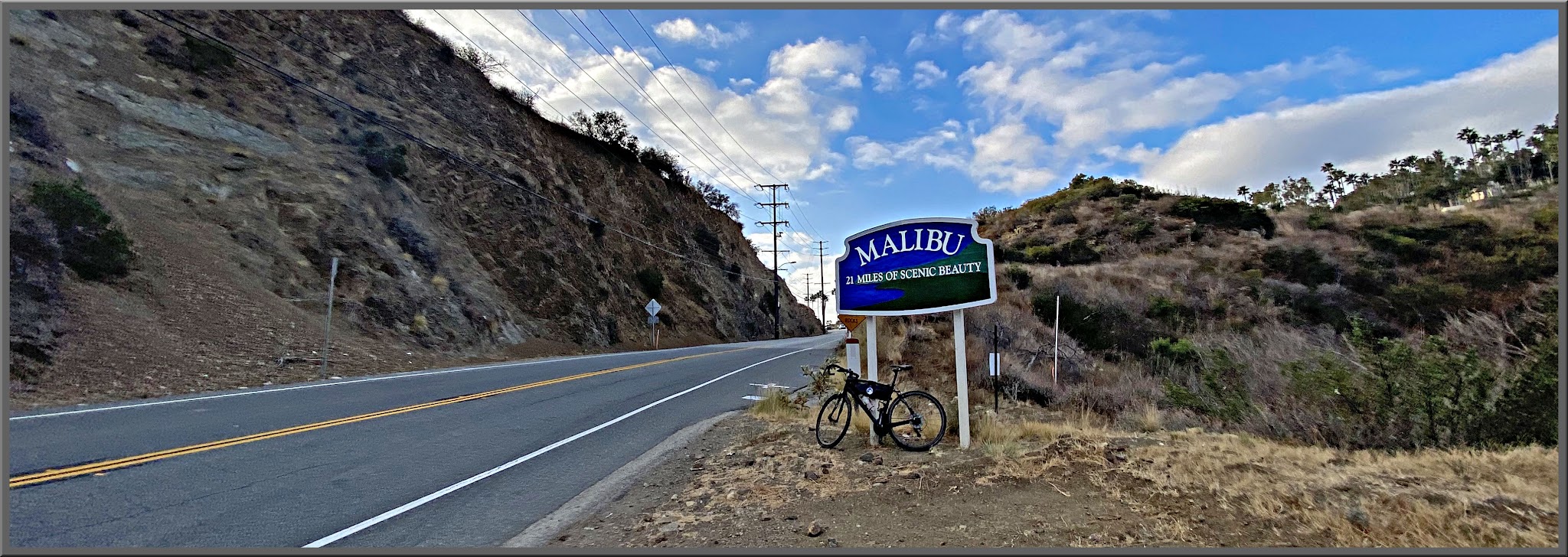 Cycling Malibu Canyon Road to the top of Piuma Road - bike parked on roadside next to sign for Malibu