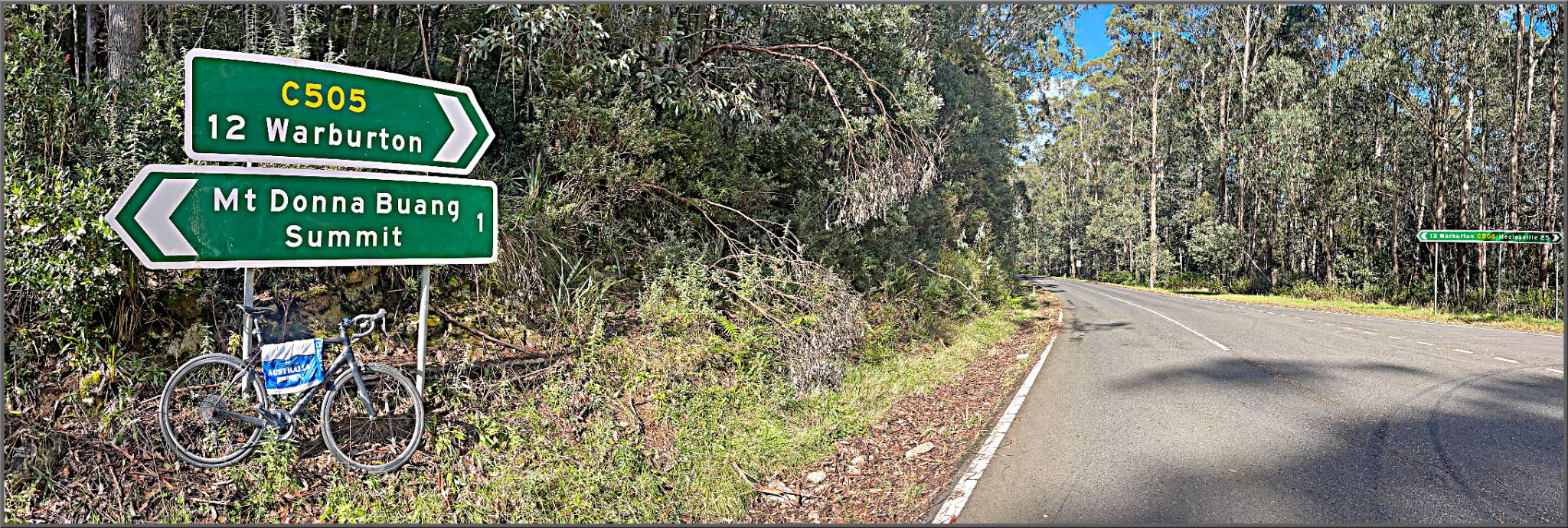 Cycling Donna Buang, Victoria, Australia bike parked in front of road sign for Mt. Donna Buang Summit