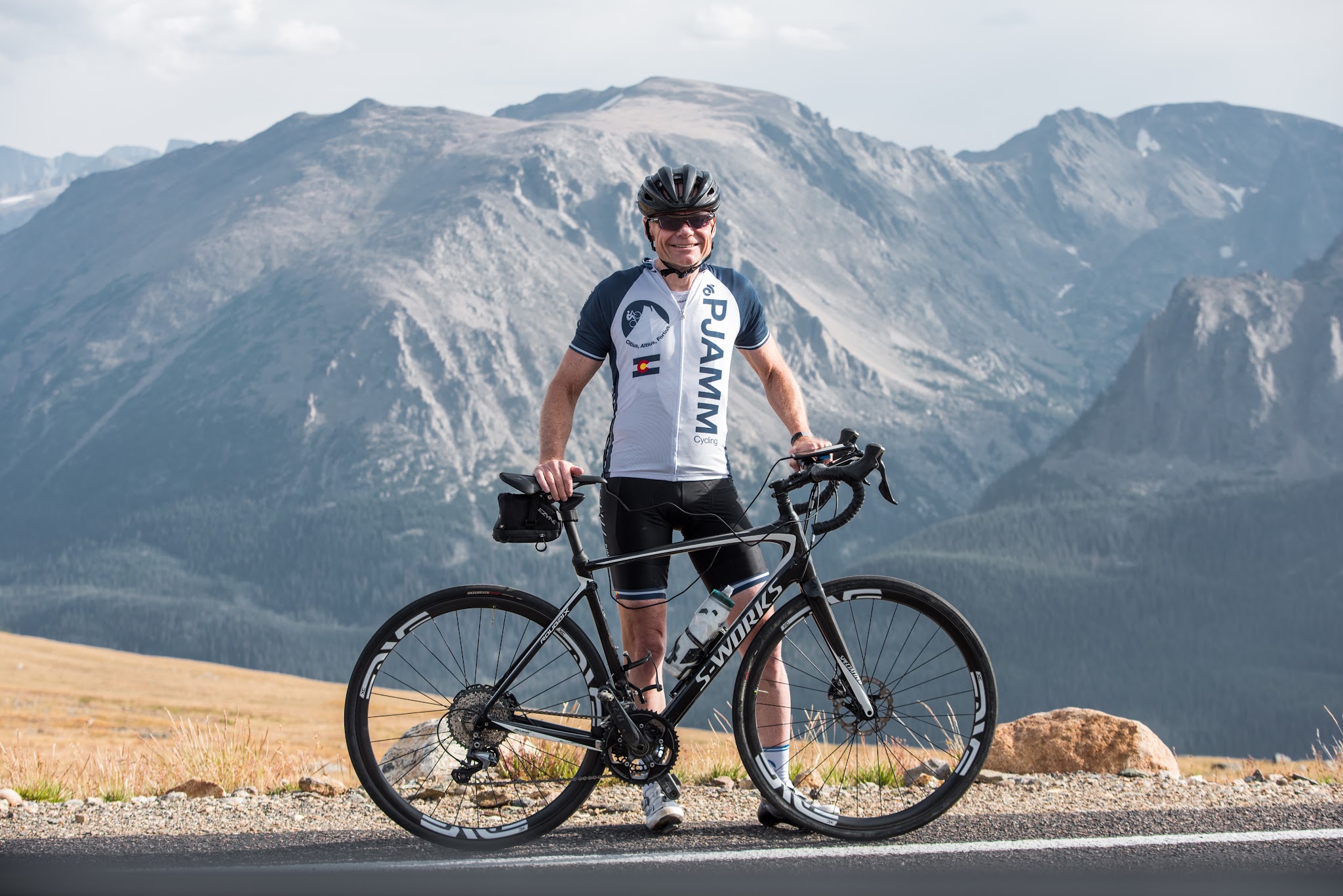 John Johnson PJAMM Cycling with bike at high point of Trail Ridge bike climb
