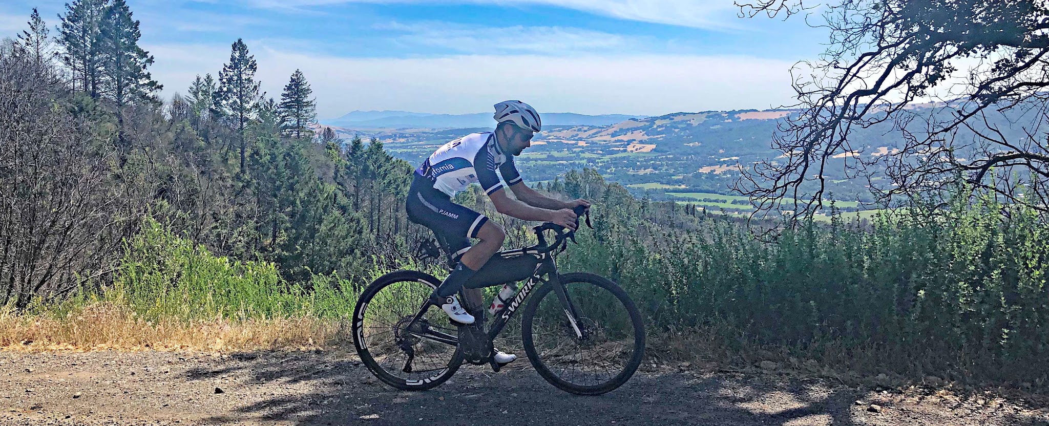 Cycling Cavedale Road - cyclist riding on road - mt tam and sonoma valley in background