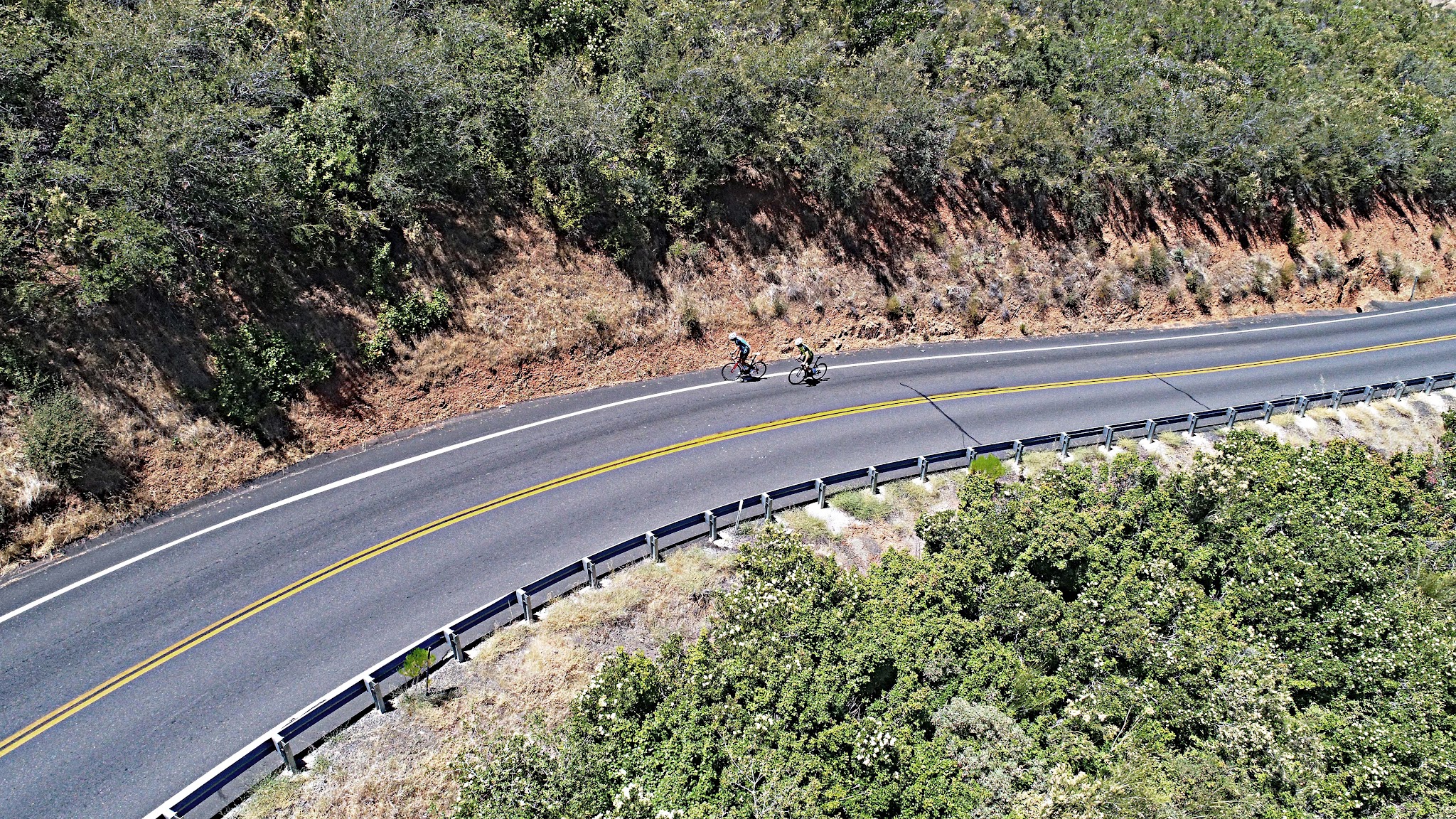 Bicycle ride up Old Priest Grade - aerial drone photo of 2 cyclists riding on road
