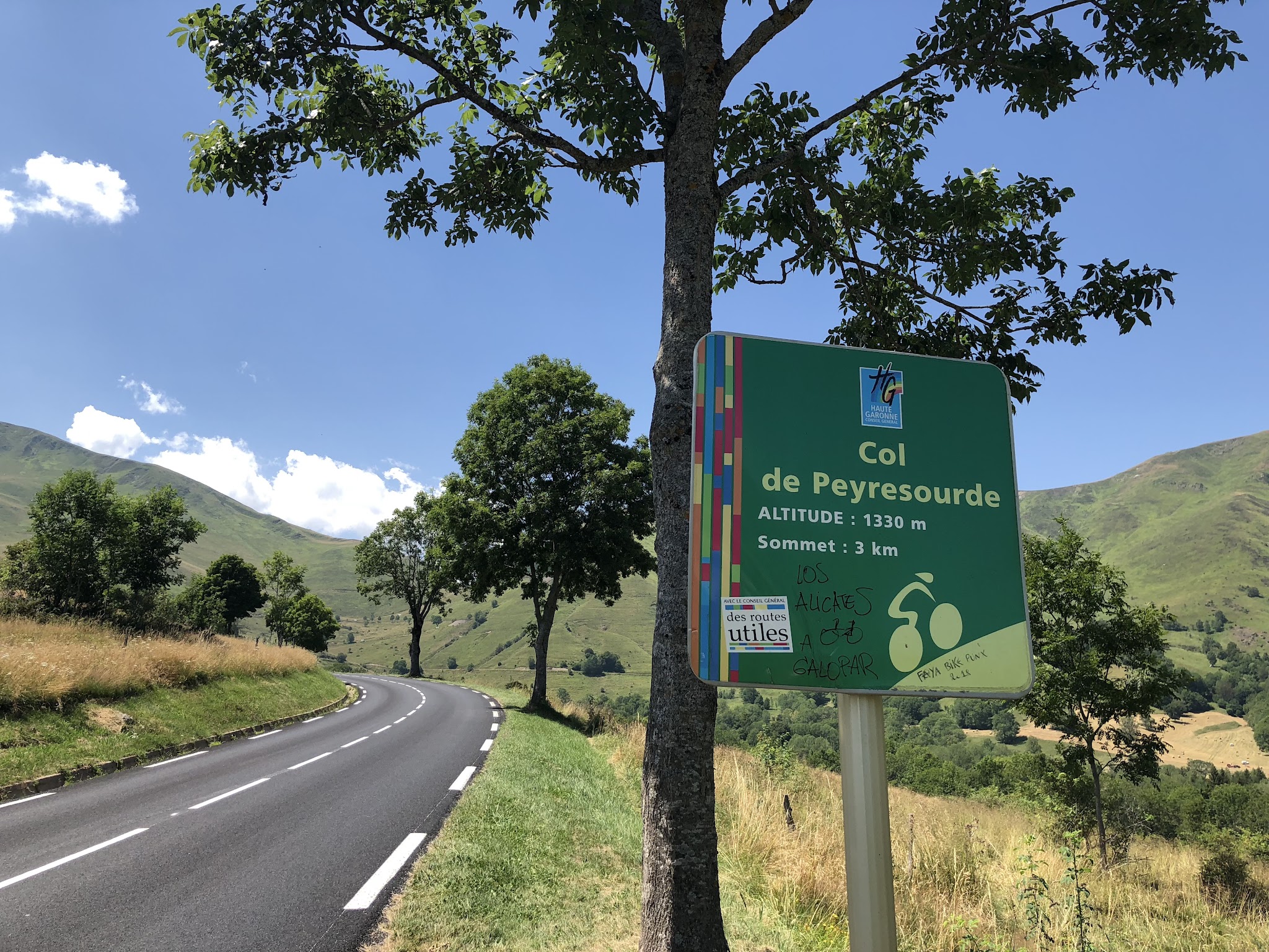 Cycling Col de Peyresourde from Bagneres-de-Luchon - roadway, trees and km sign