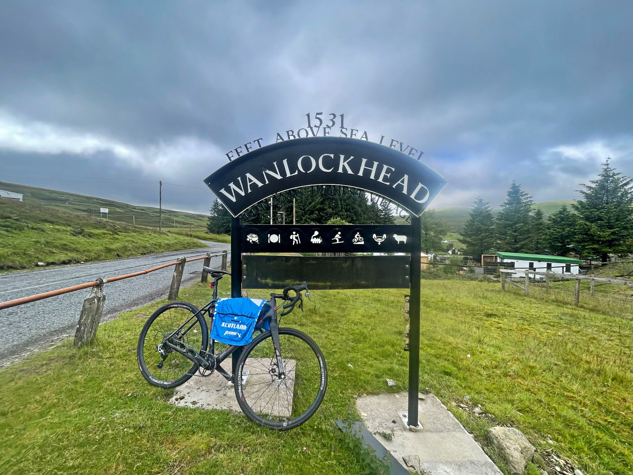 bike parked against iron sign for Wanlockhead Village