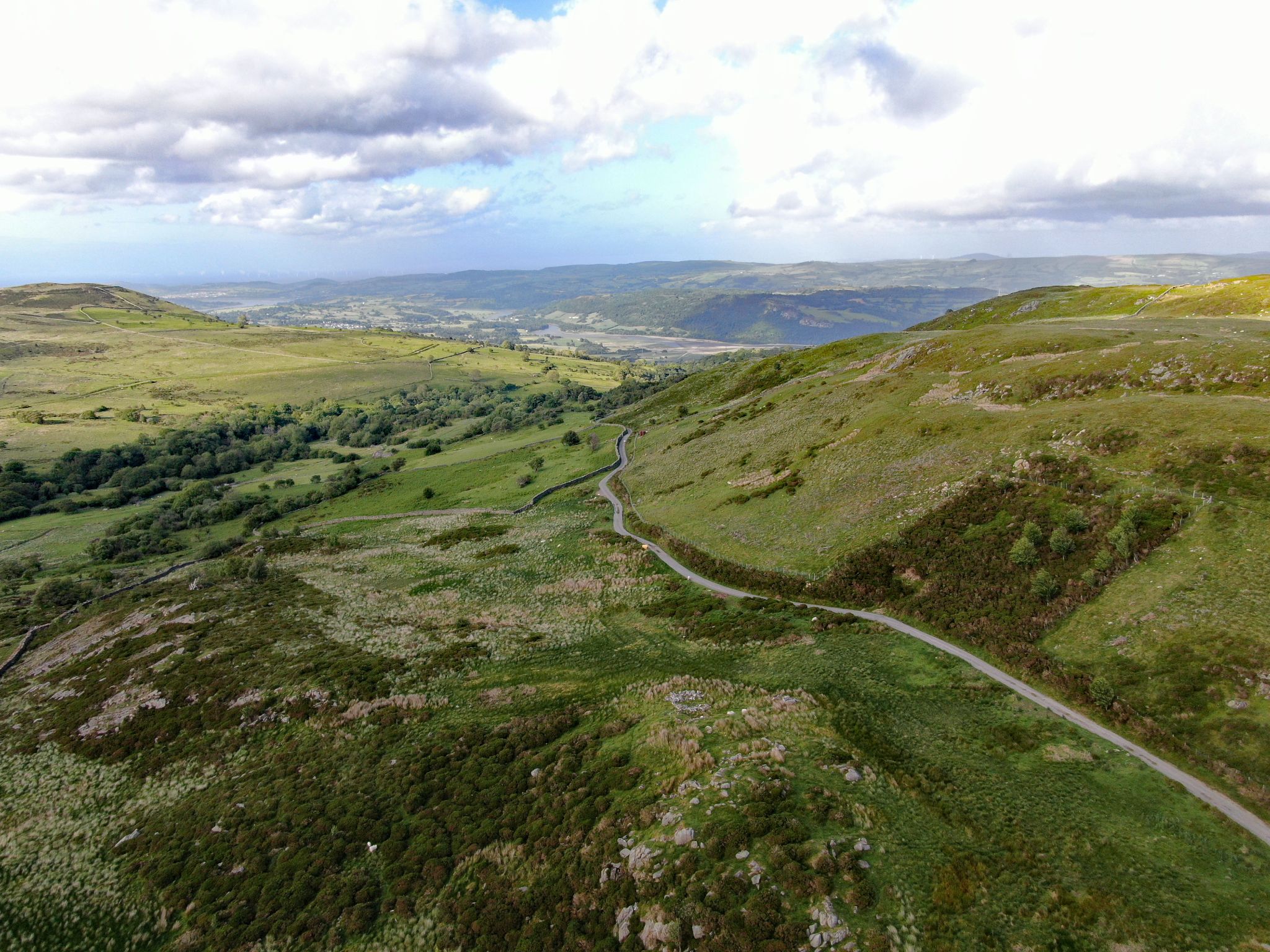 aerial view shows roadway stretching through pastureland at climb's finish