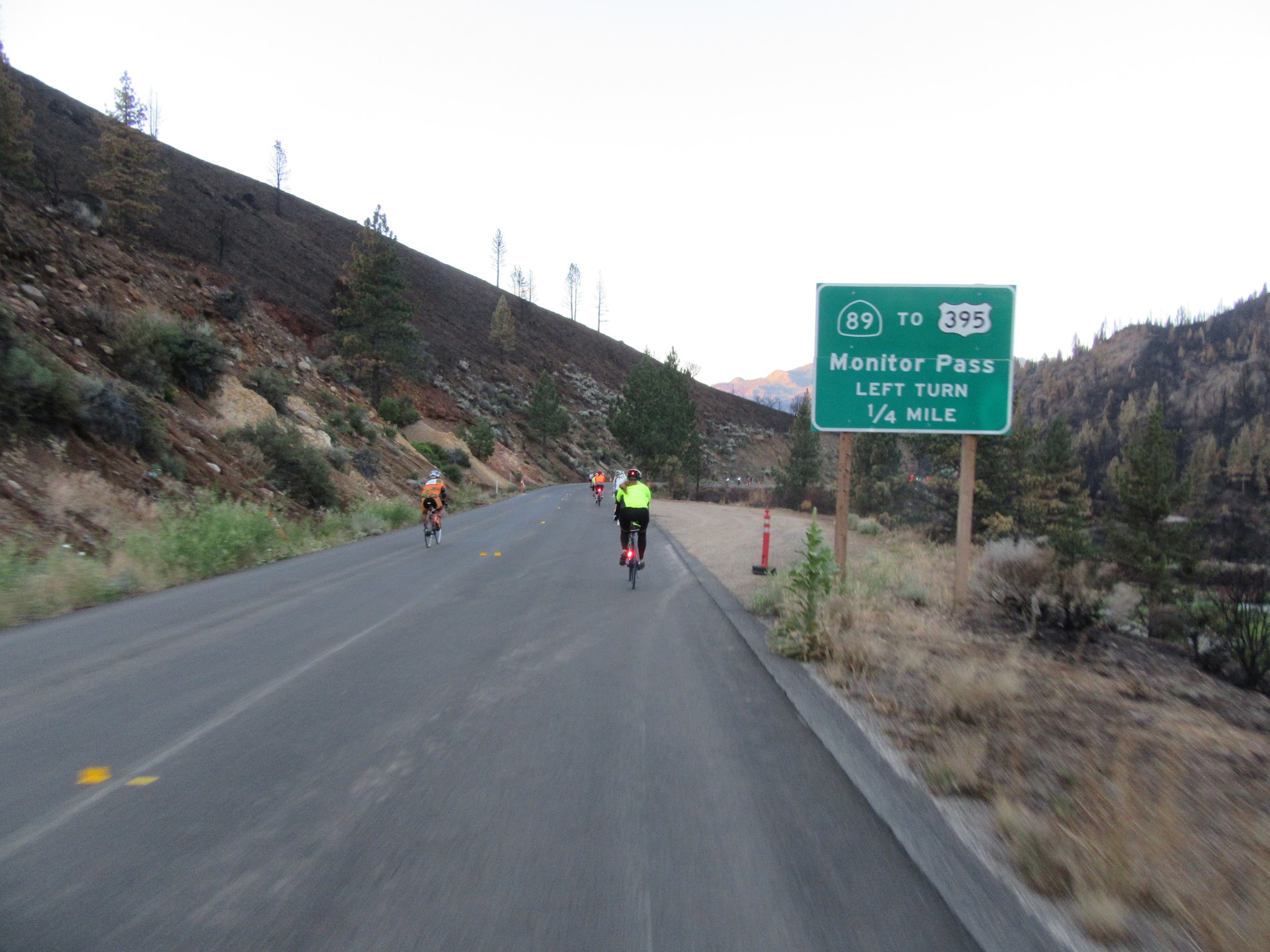 Cycling Monitor Pass West - beginning of climb - Death Ride - cyclists and Monitor East and West road sign