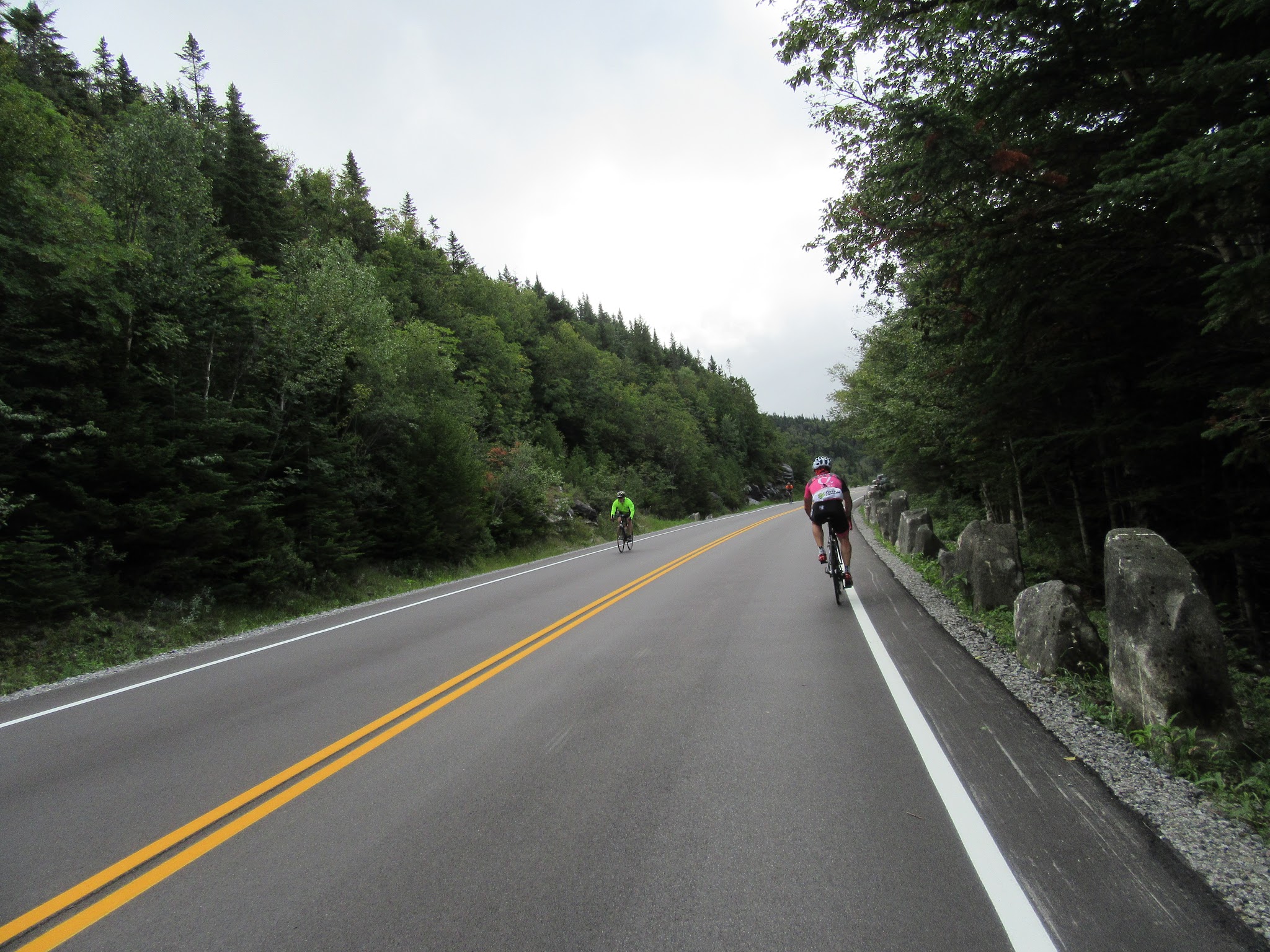 Climbing Whiteface Mountain by bike - cyclists riding on pristine two-lane roadway.