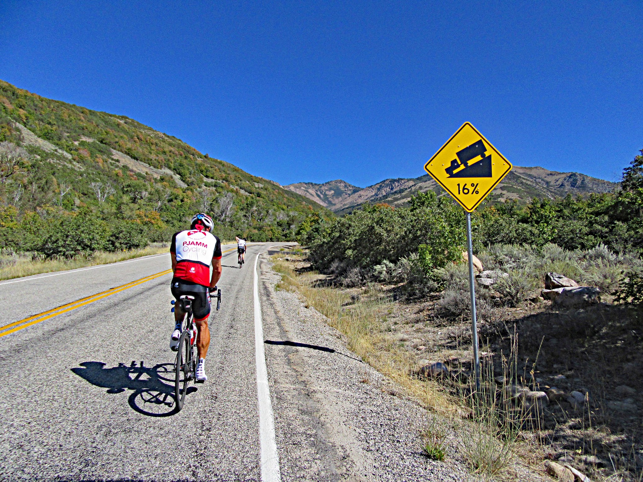 PJAMM bicyclist passing steep grade sign on Powder Mountain bike climb
