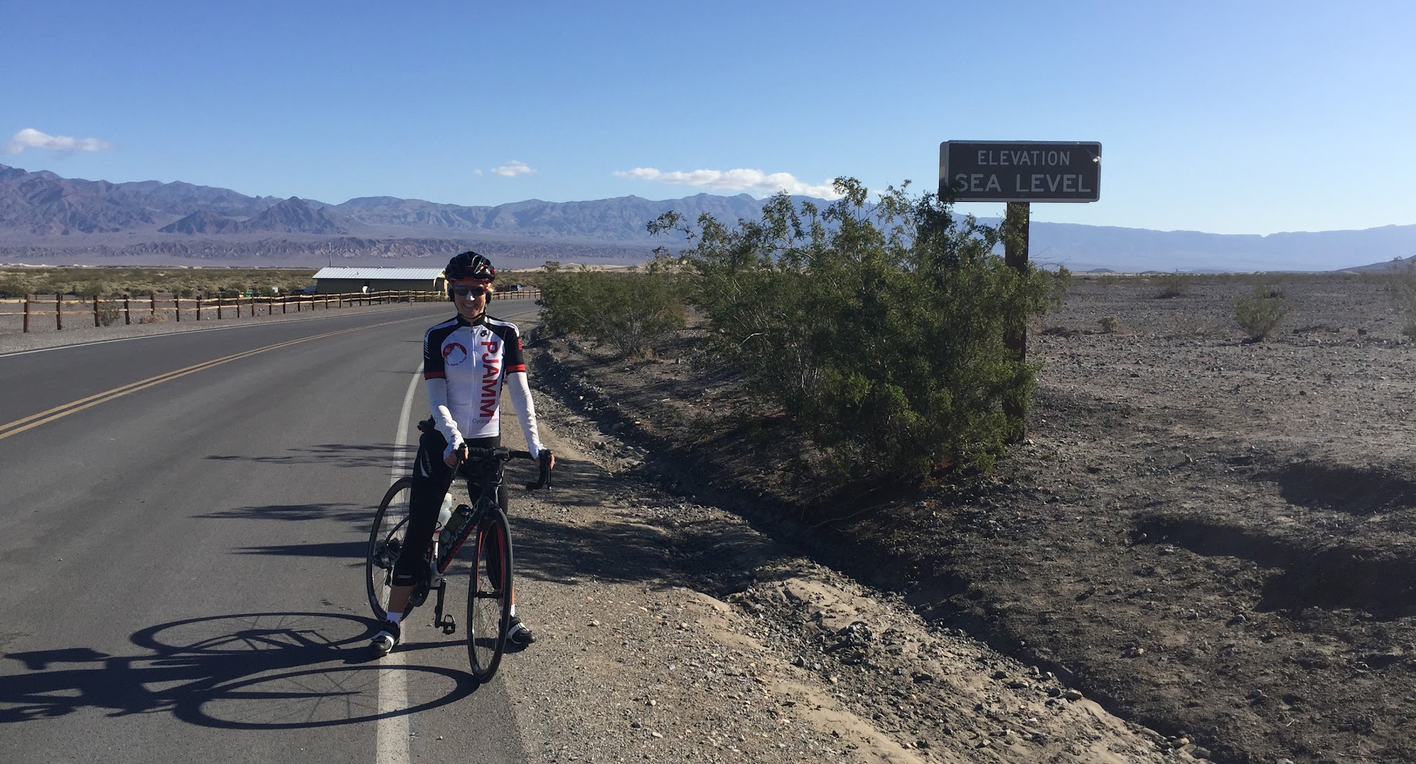 Emigrant Pass, Death Valley National Park Emigrant Pass, Death Valley National Park - climb by bike - cyclist in Stovepipe wells at Sea Level sign