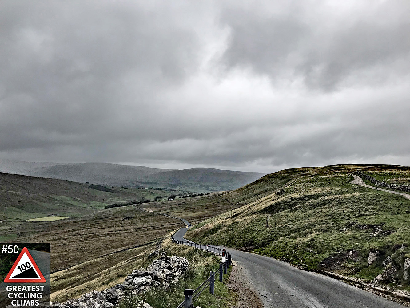 Cycling Fleet Moss, England moody clouds cover one-lane country road surrounded by pastureland and low stone fences