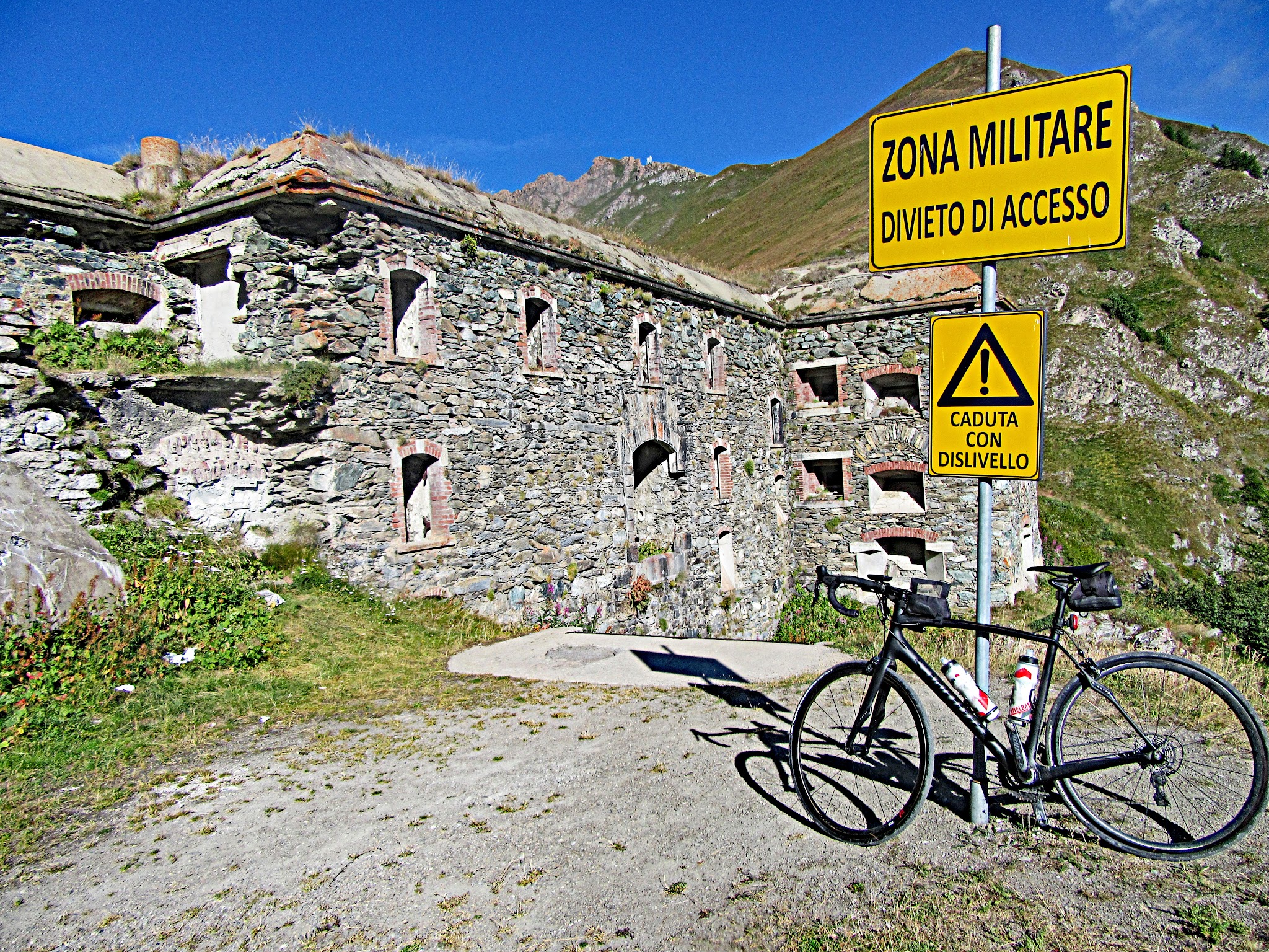 climbing Colle delle Finestre  by bike - military fort, sign, bicycle