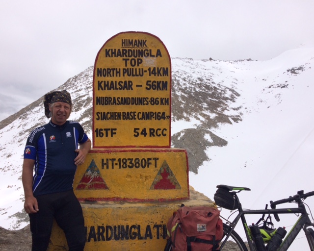 Biking Khardung La Pass - cyclist at pass sign