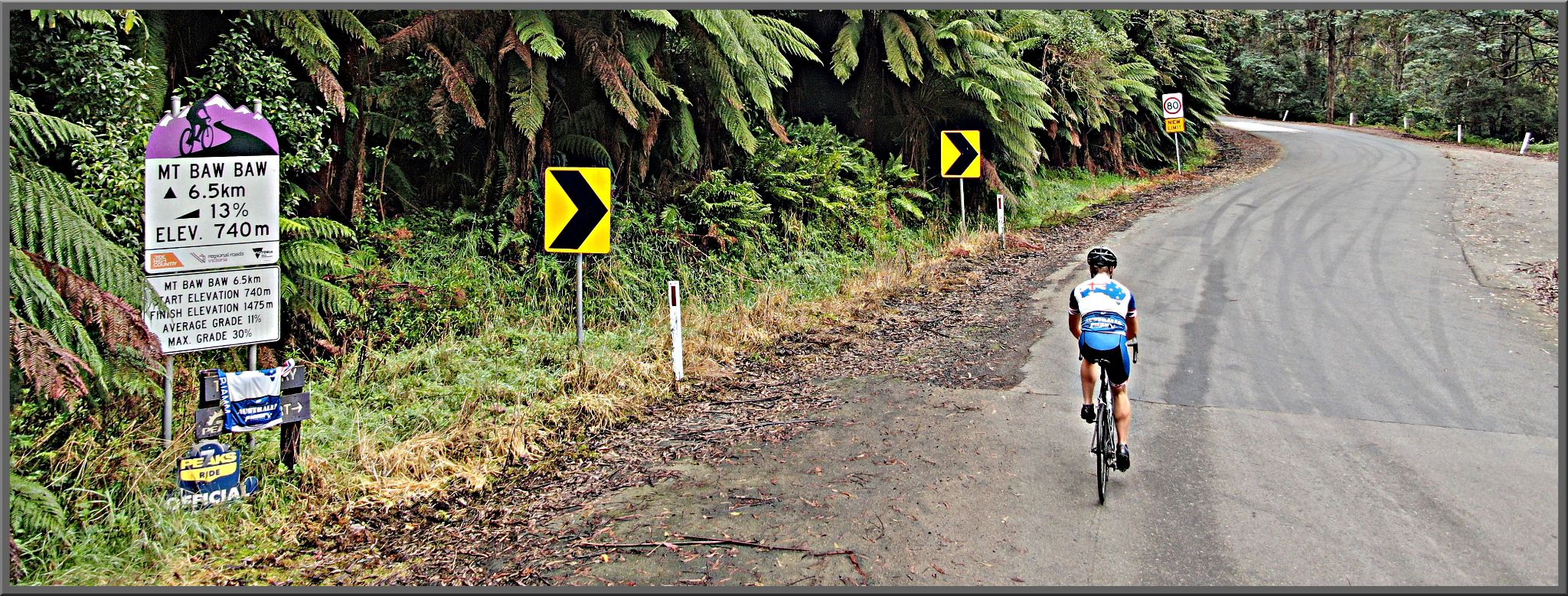PJAMM Cyclist rides on roadway past Tour down Under sign for Mt. Baw Baw