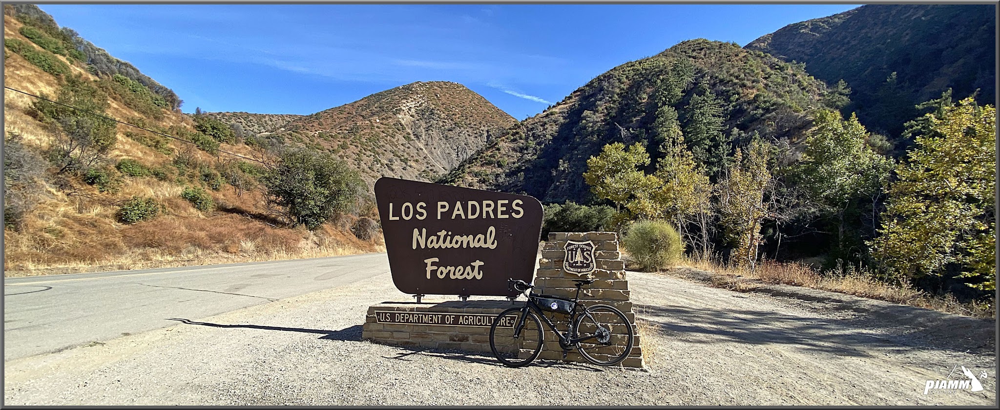 Cycling Highway 33 to Pine Creek Summit - bike parked next to sign for Los Padres National Forest