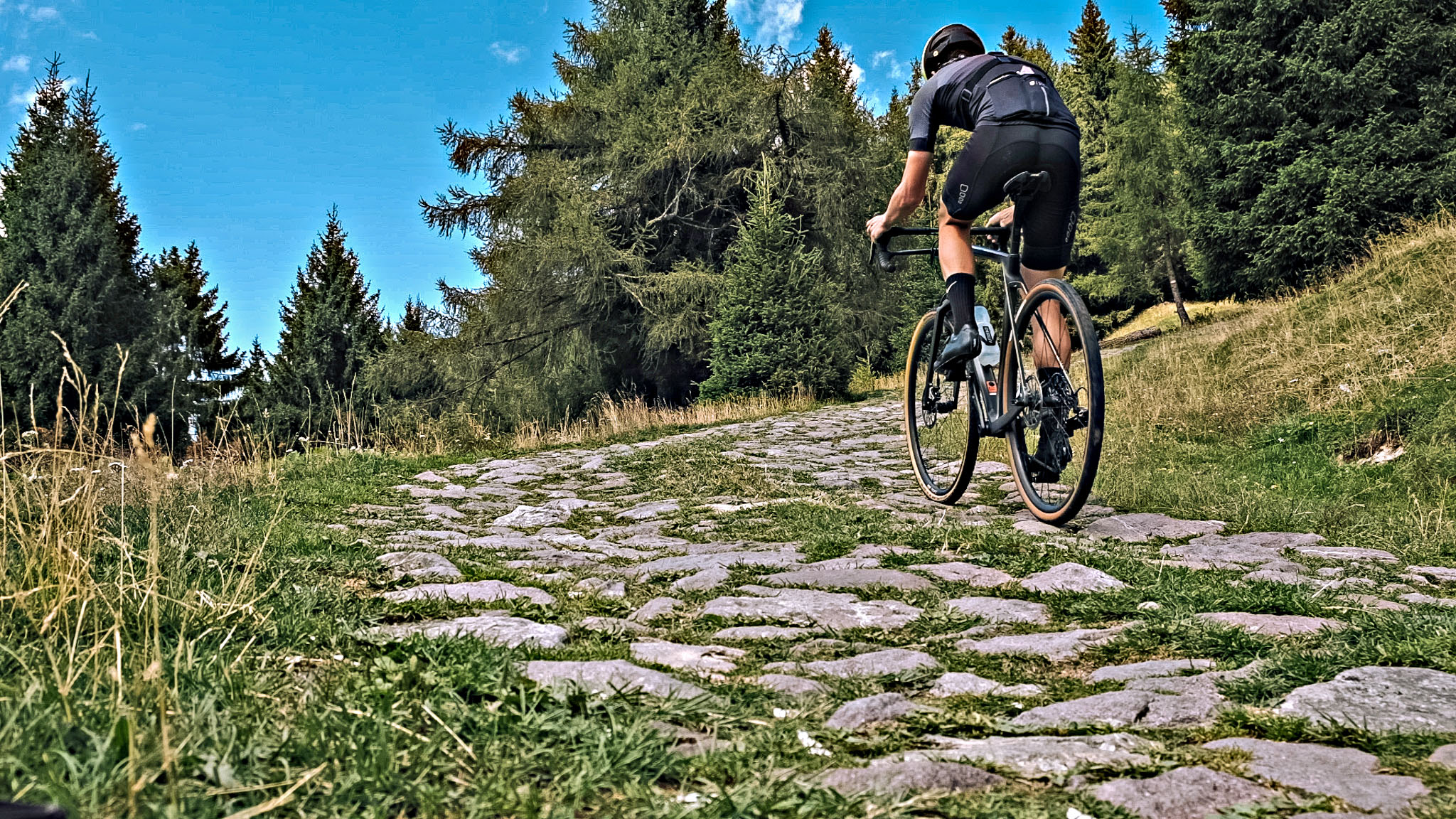 Cycling Pozza San Glisente, Italy - cyclist riding on cobblestone roadway