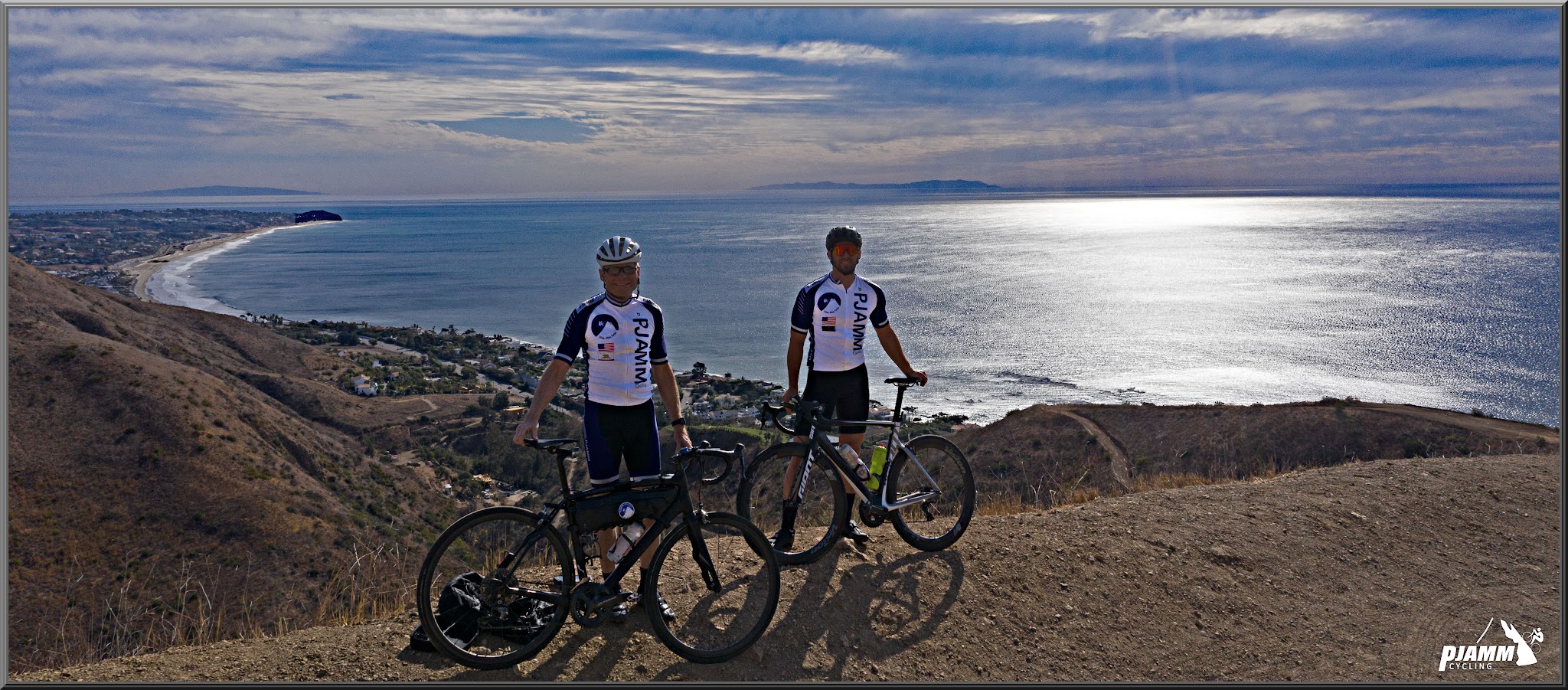 Cycling decker Road to Yerba Buena high point - two PJAMM Cyclists stand with bikes on hillside over looking pacific ocean, Santa Monica Mountains