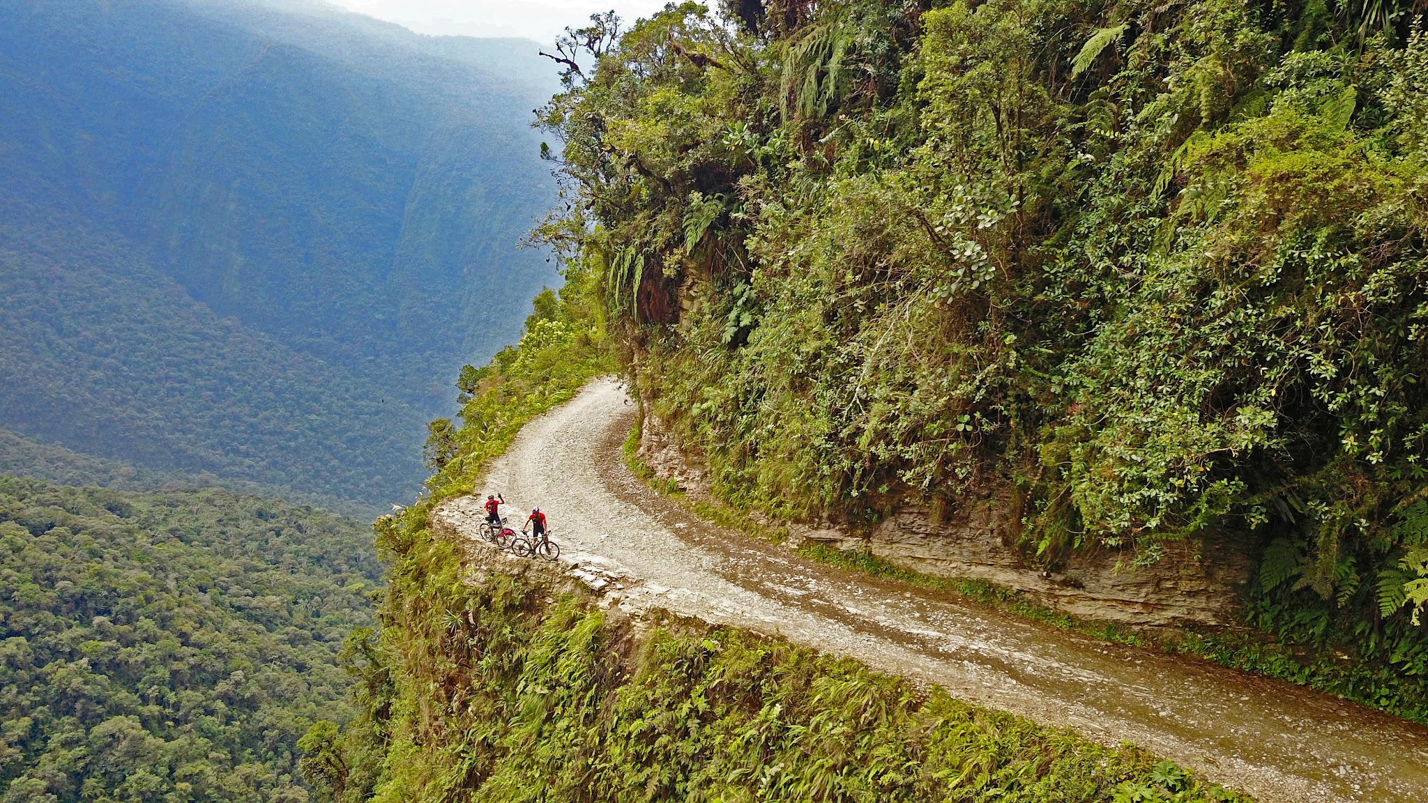 Death Road - Postcard Corner 2 cyclists sitting on cliff on Death Road Bolivia Postcard Corner