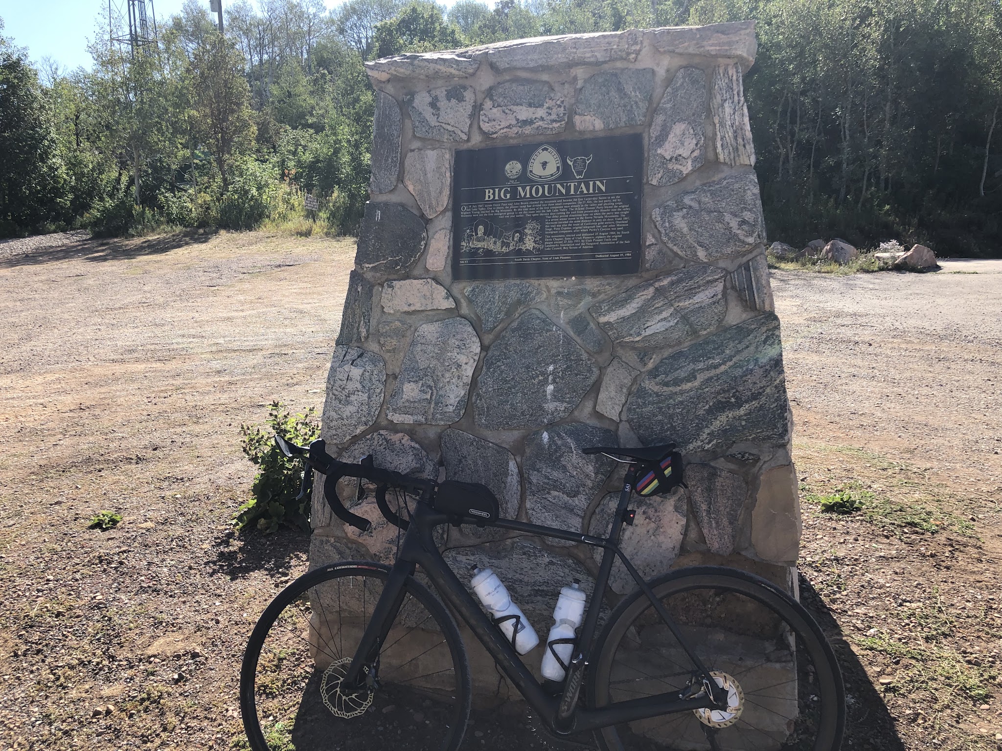 cycling Big Mountain Summit West - bike leaning against Big Mountain Summit monument.