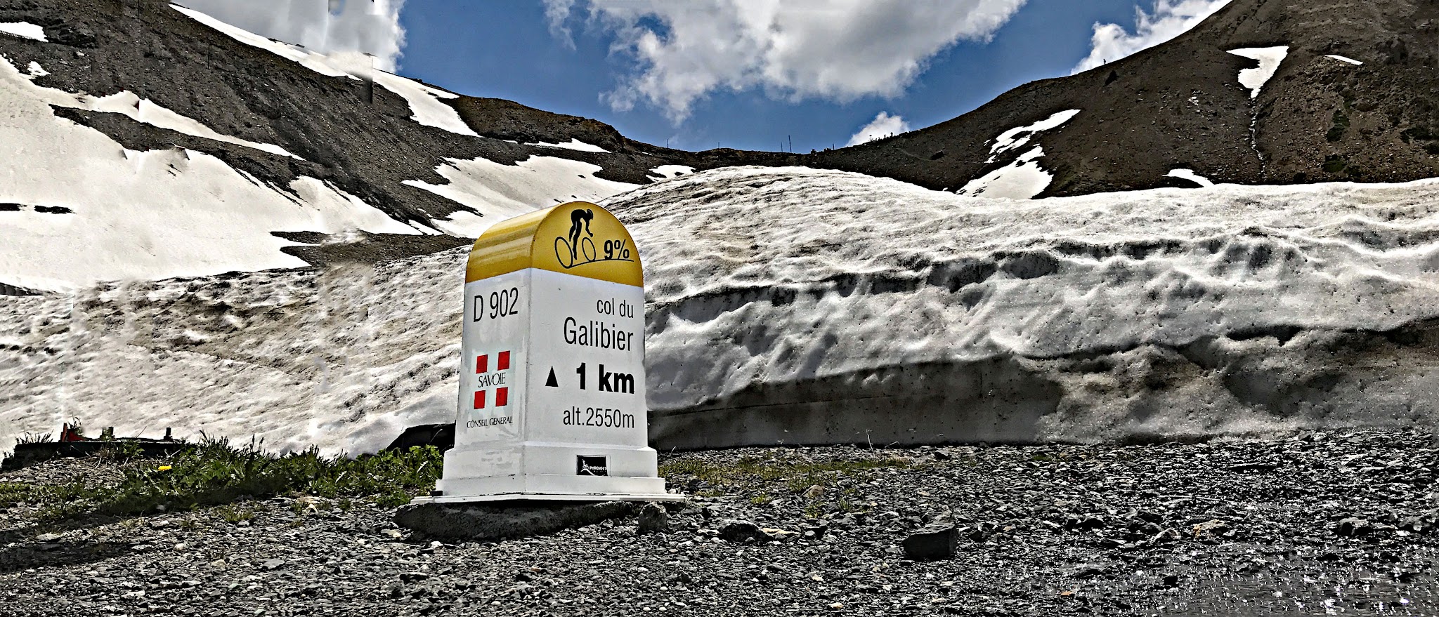 Cycling Col du Galibier and Telegraphe - KM marker for Galibier surrounded by snow banks