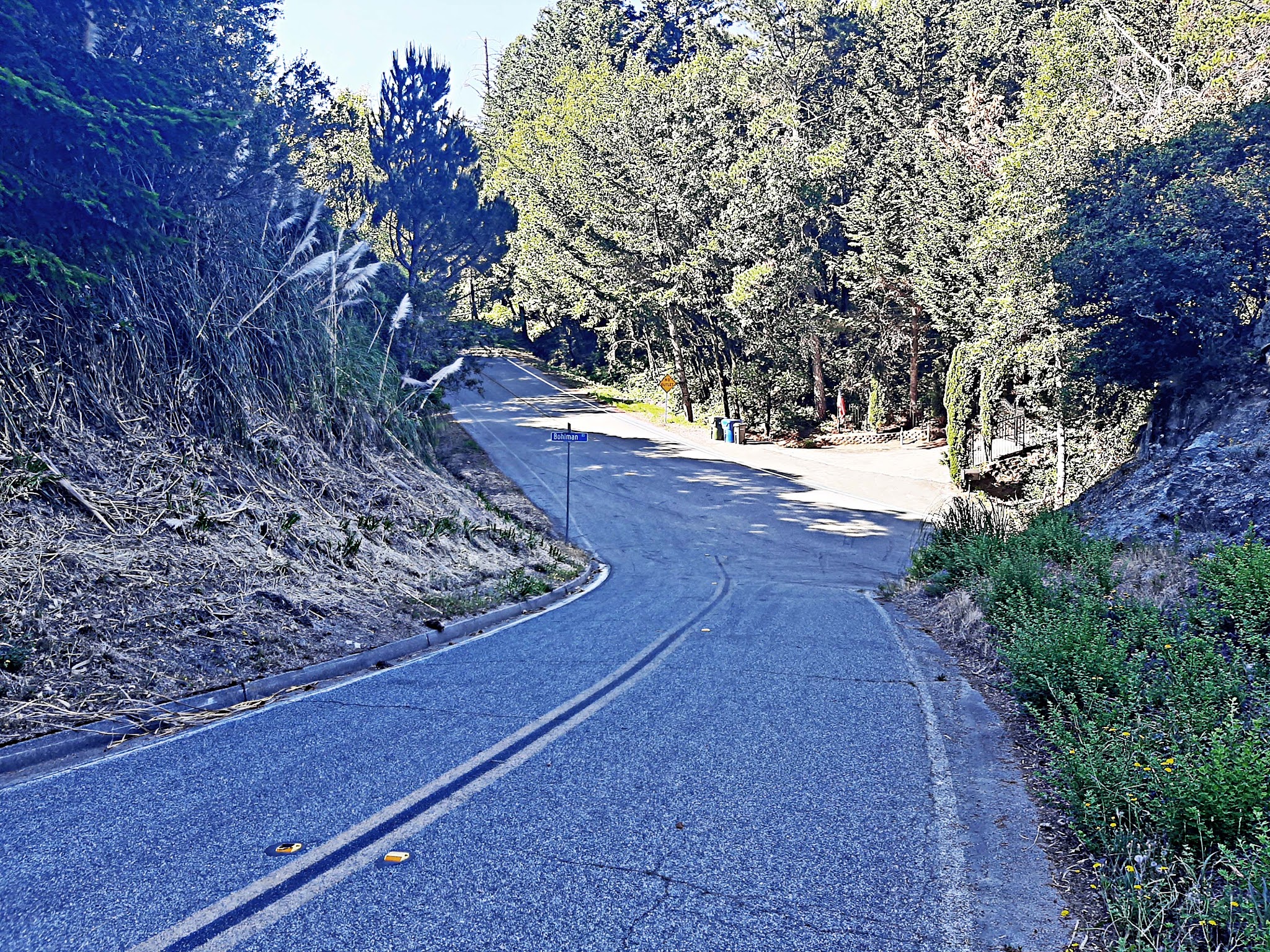 Cycling Bohlman On Orbit - view along two lane road in hillside showing brief descent