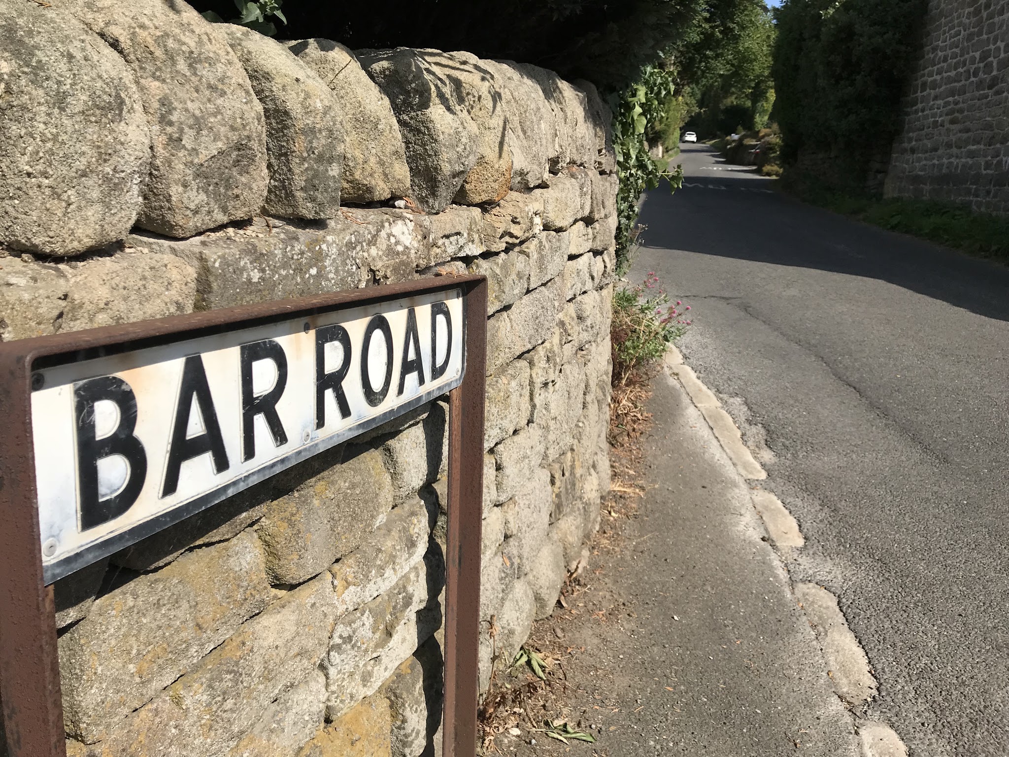 stone fence with road sign for Bar Road