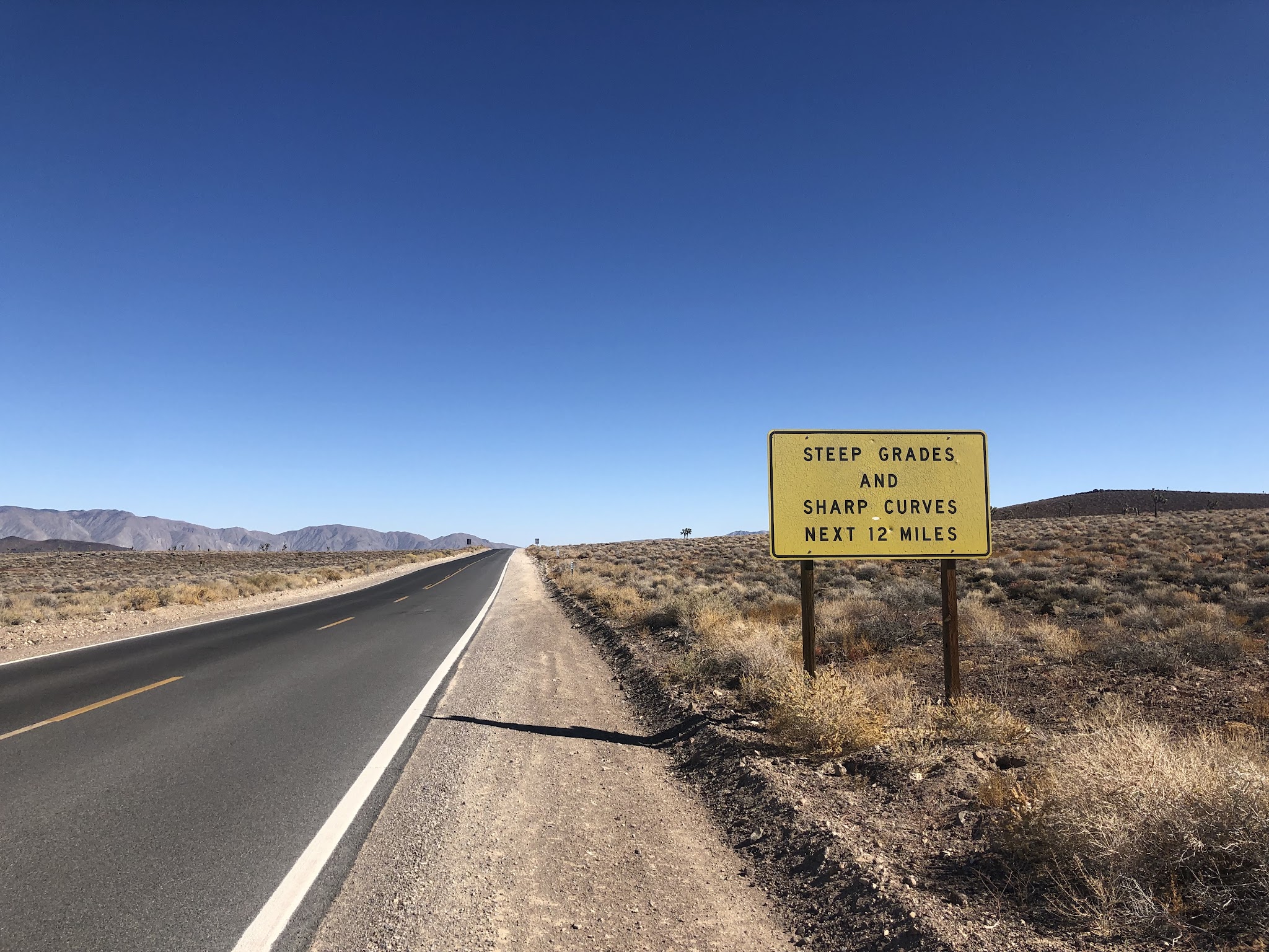 Biking Panamint Grade - steep grade sign, road and mountains
