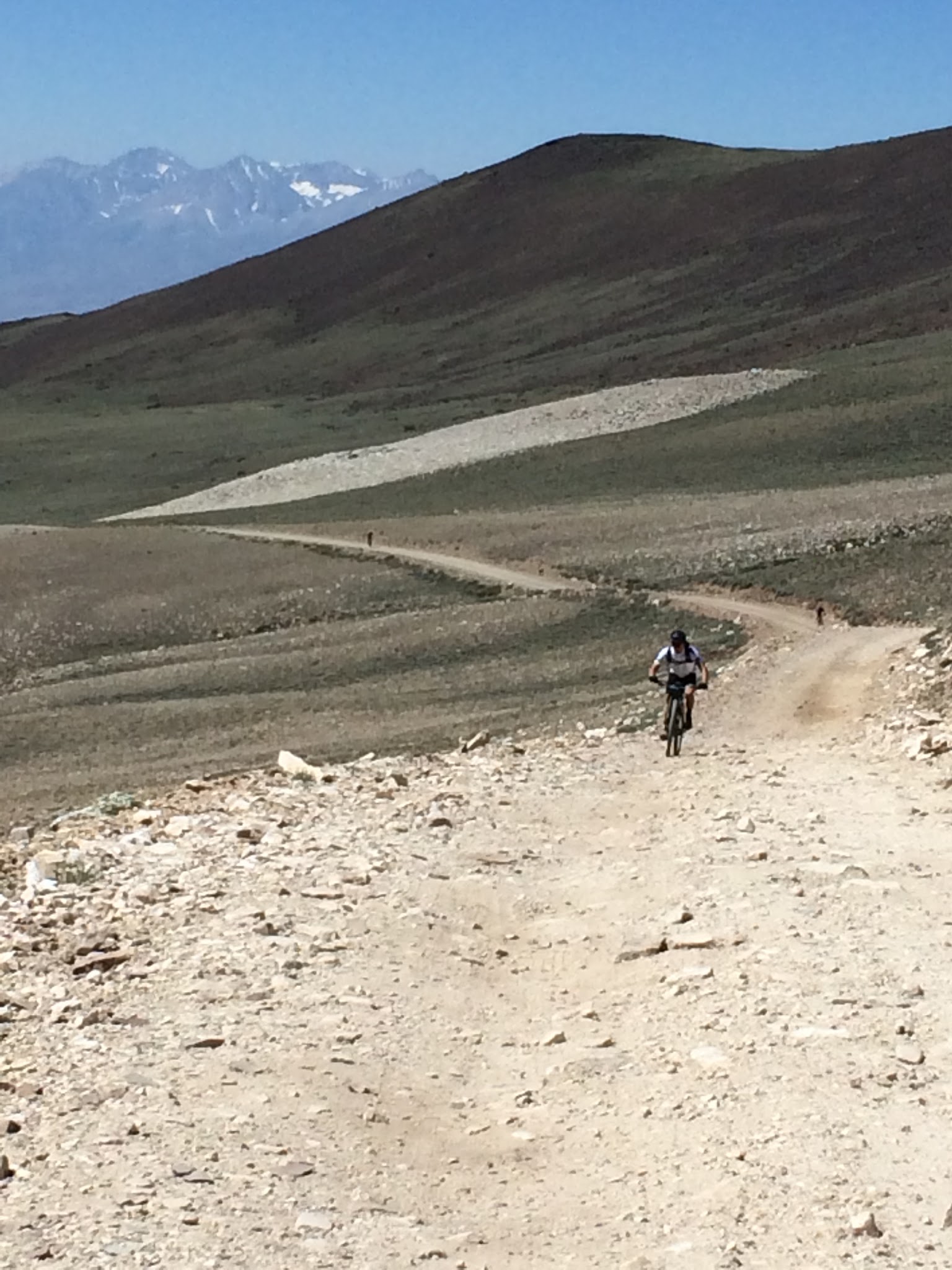White Mountain Peak from Big Pine, California - cyclist rides on mountain bike up gravel roadway