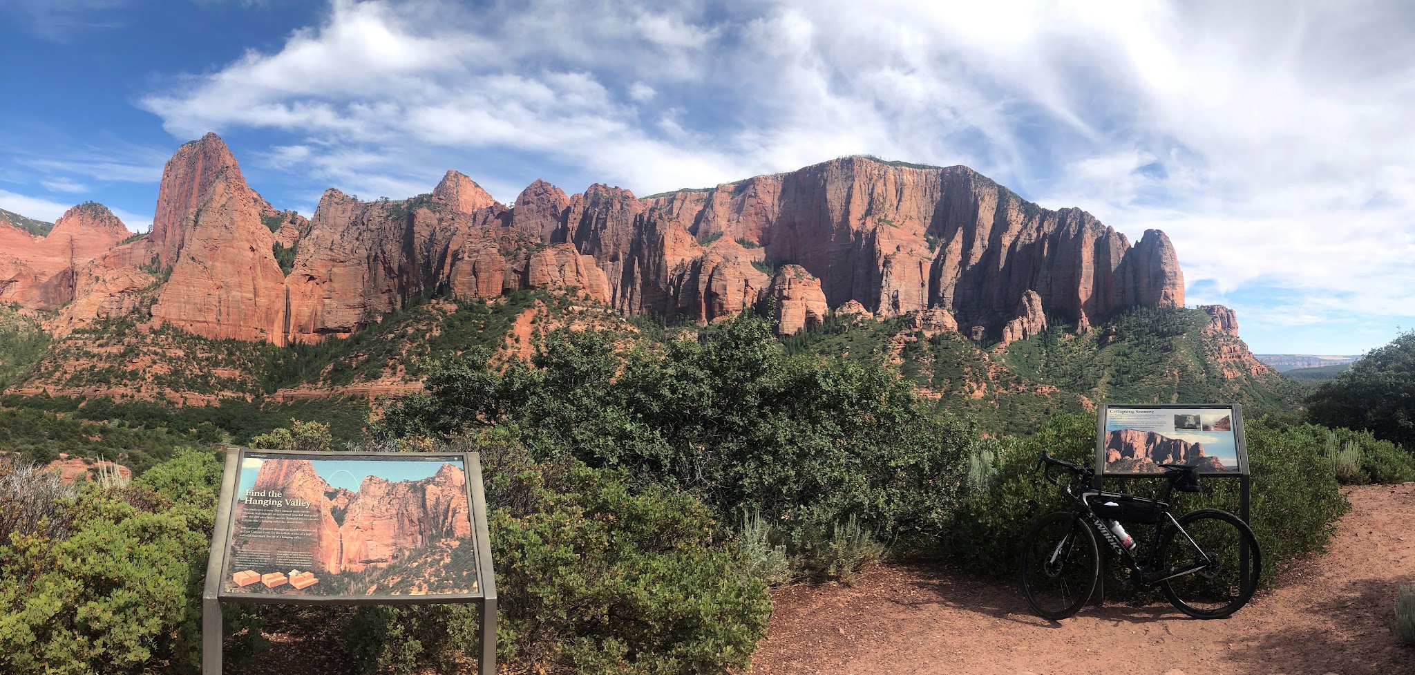 Climbing Kolob Canyon Road by bike - bicycle, information signs and rock formations at viewpoint