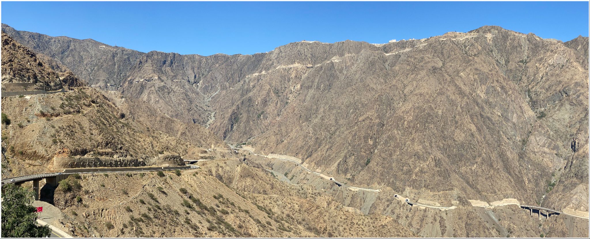 Cycling Al Bahah Pass, Saudi Arabia - panoramic view shows mountain road carved into the side of the Asir Mountains