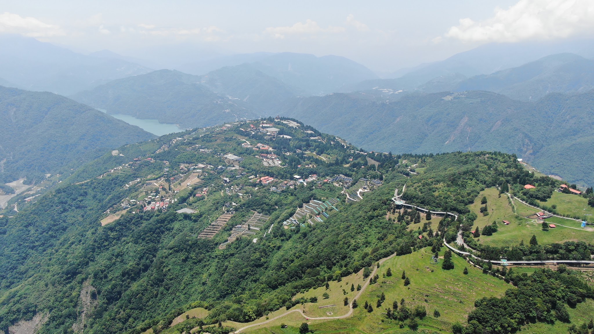 Climbing Wuling Pass West by bike - Cingjing Skywalk from aerial drone, walkway, mountains, farm and reservoir