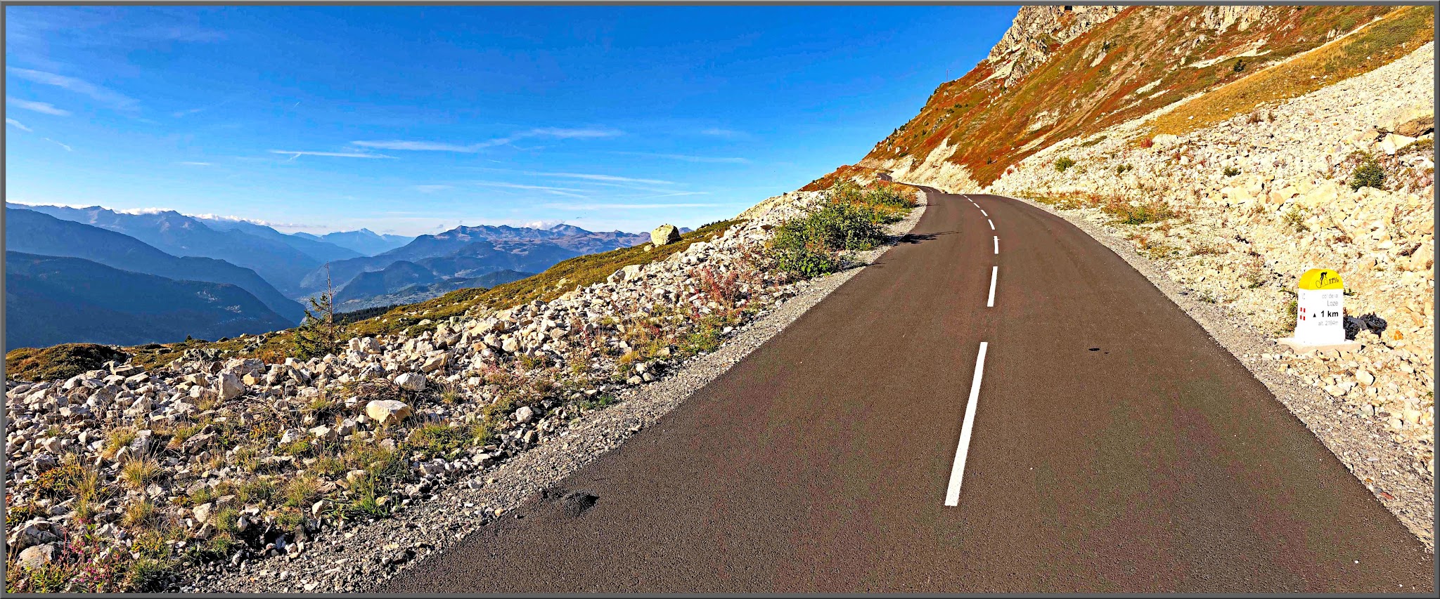 Cycling Col de la Loze, Tour de France 2023: Two-lane mountain roadway, newly repaved, rocky mountain hillsides on either side, 