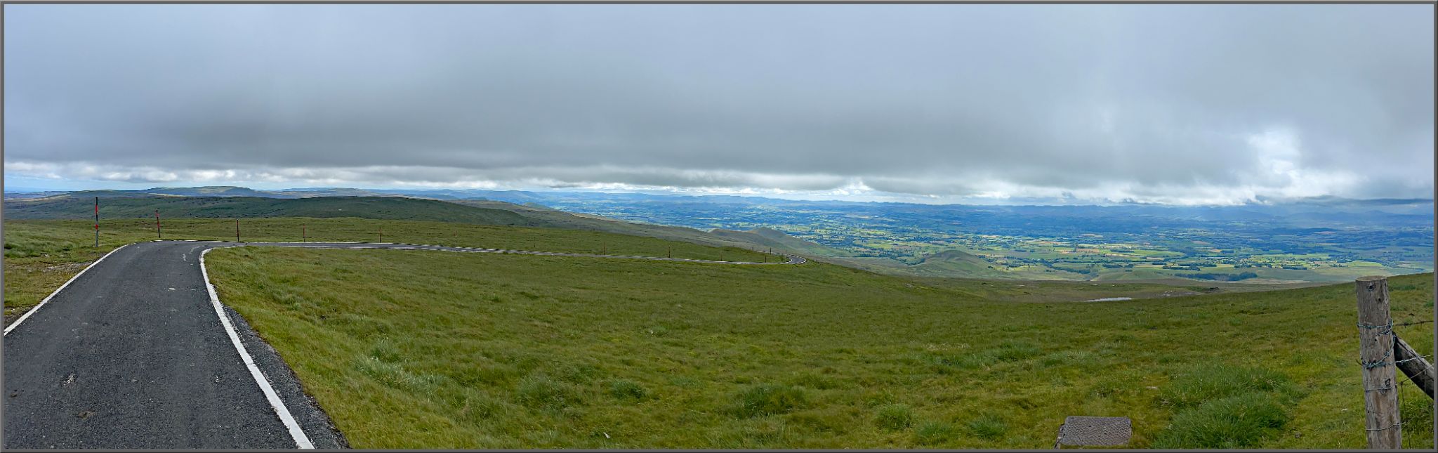 sweeping view of green pastureland and straight stretch of newly paved roadway