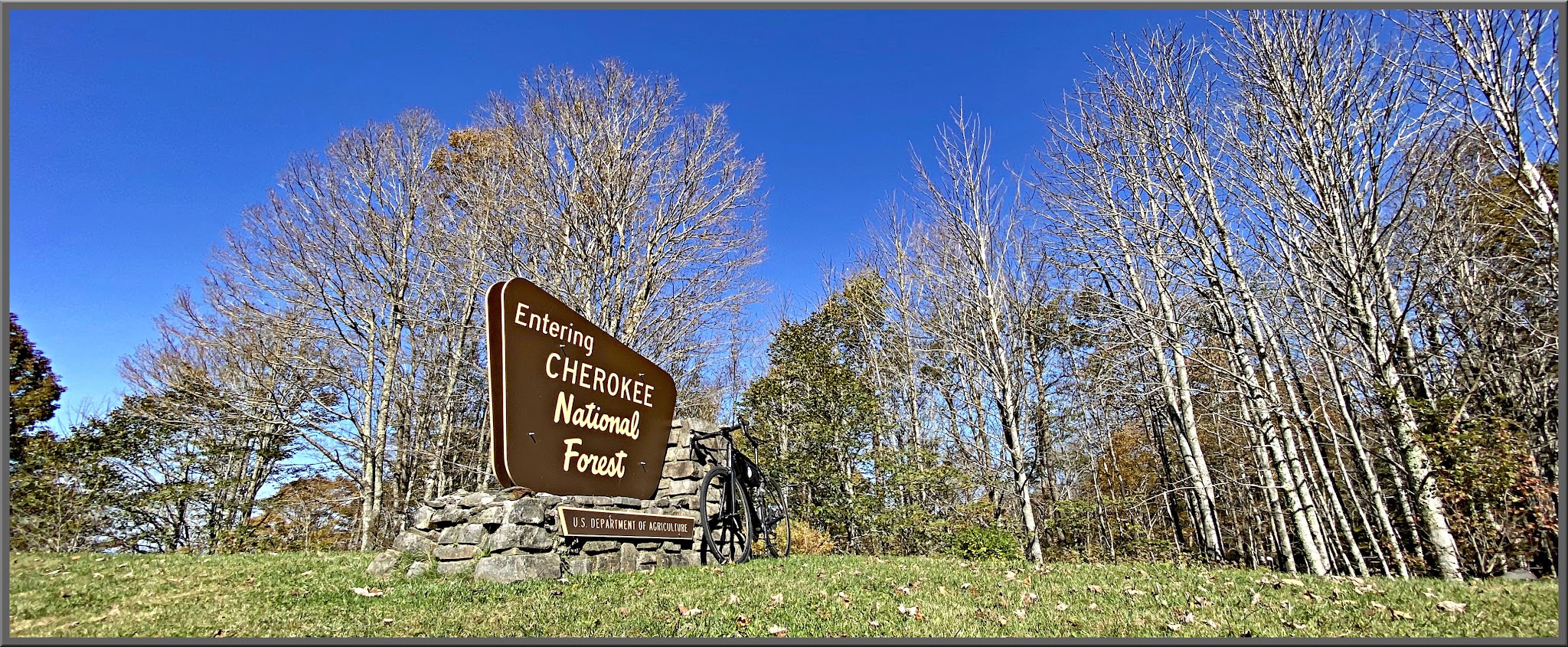 Cycling Cherohala Skyway, Tennessee - bike parked in front of NPS sign for Cherokee National Forest