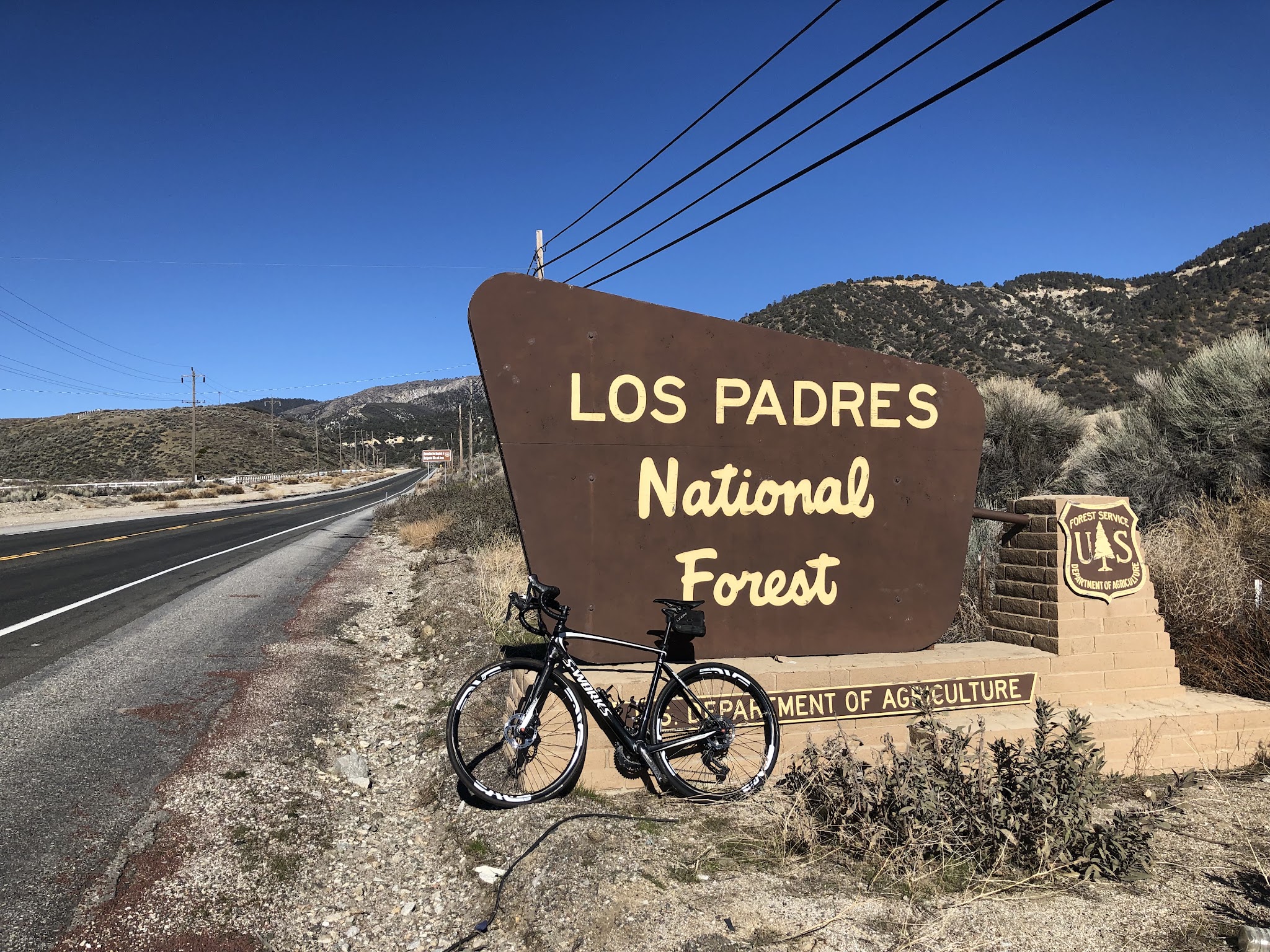 Bike climb Mt. Pinos - bike leaning against Los Padres National Forest sign