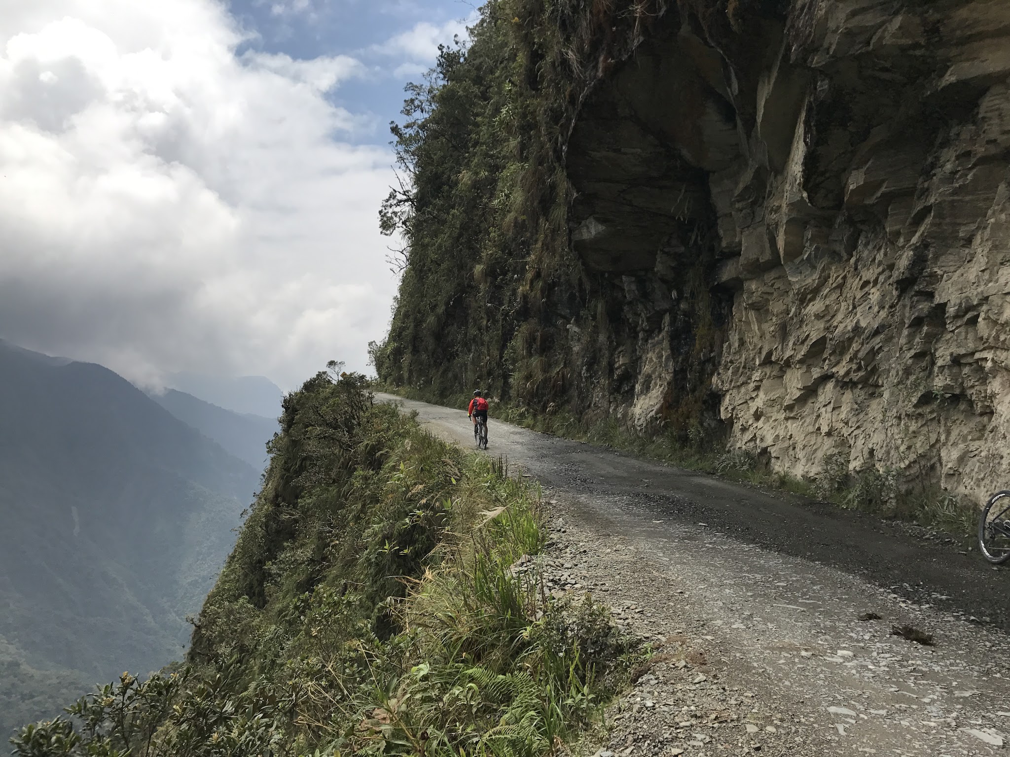 Death Road narrow road Cyclist riding bike on narrow Death Road next to cliff