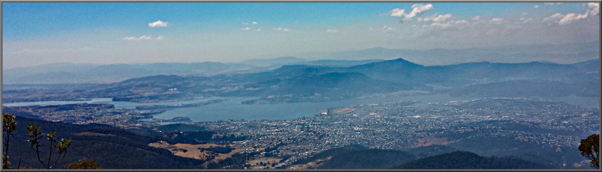 panoramic view looking down over the city, bay, mountains in background.