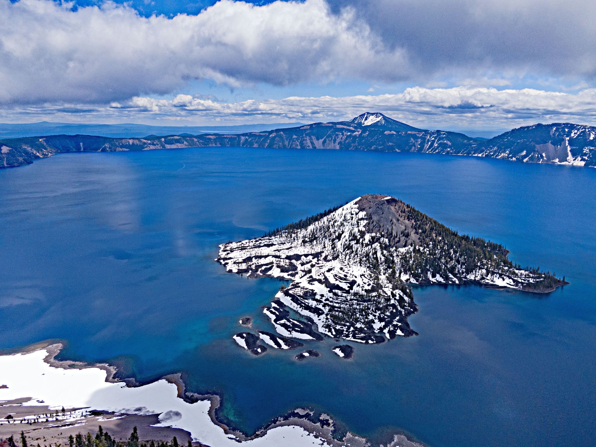 aerial drone view of Wizard Island on Crater Lake, cone shaped island, snow on island