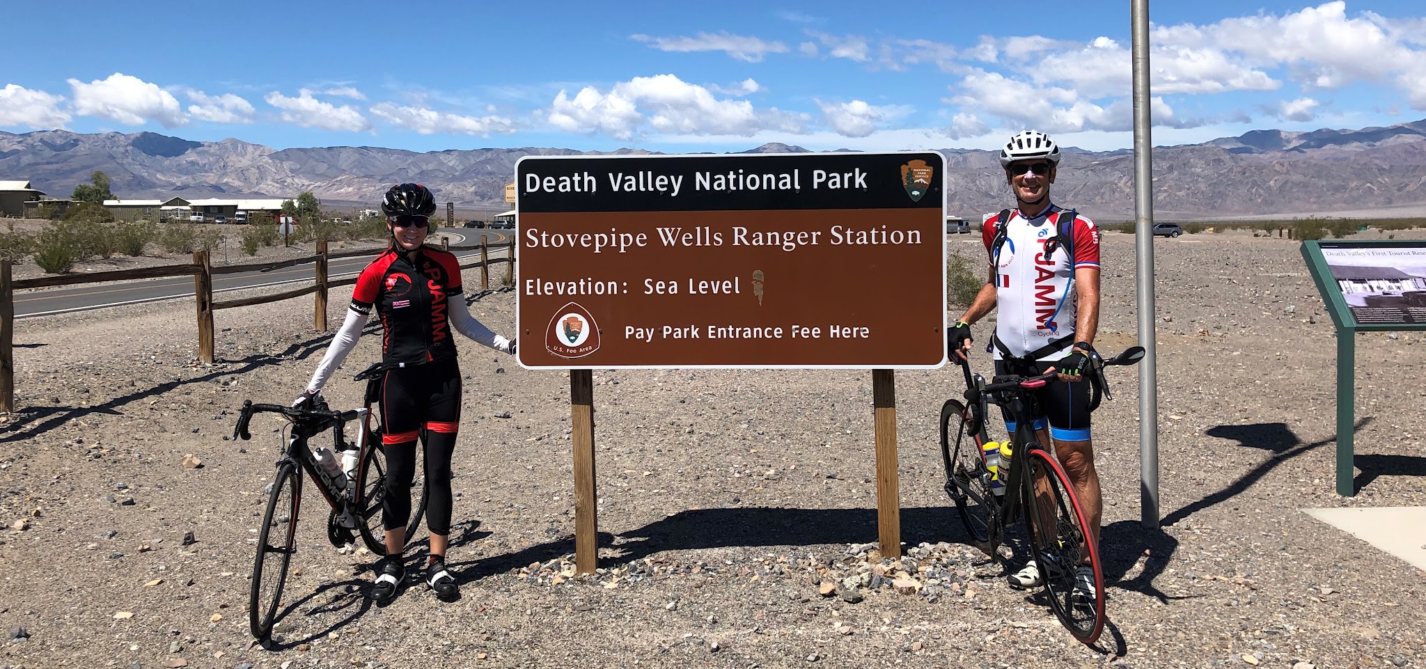 Cycling Emigrant Pass, Death Valley  - cyclists with bikes at Death Valley National Park Sign