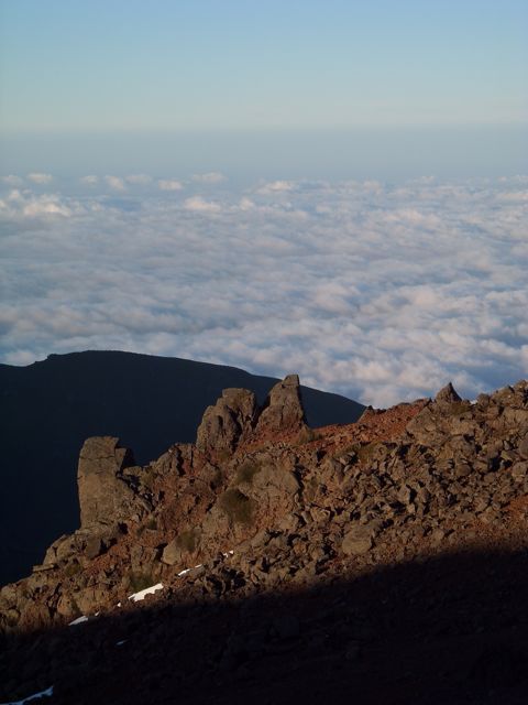 Pico Ariero as seen from above, sharp craggy rocks surrounded by clouds below