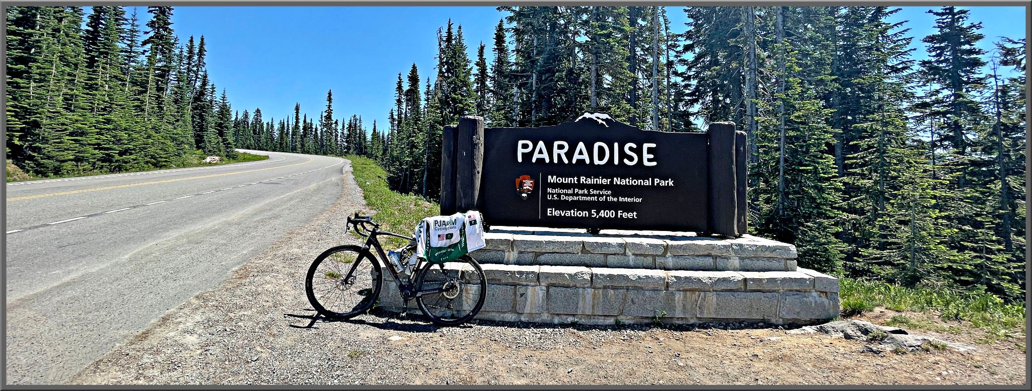 Cycling Mt. Rainier - bike parked in front of NPS sign for Paradise, Mount Rainier National Park