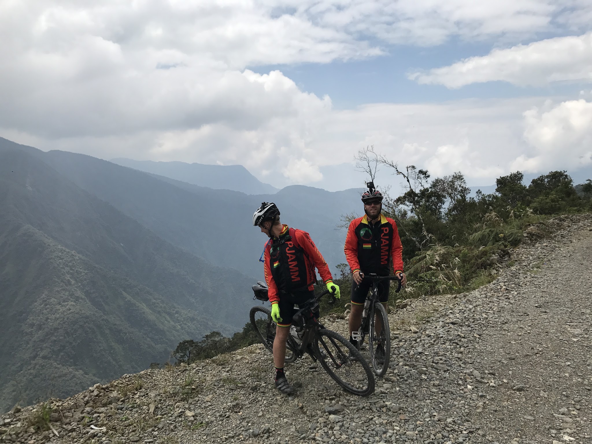 Cyclist with bike looking over cliff on Death Road