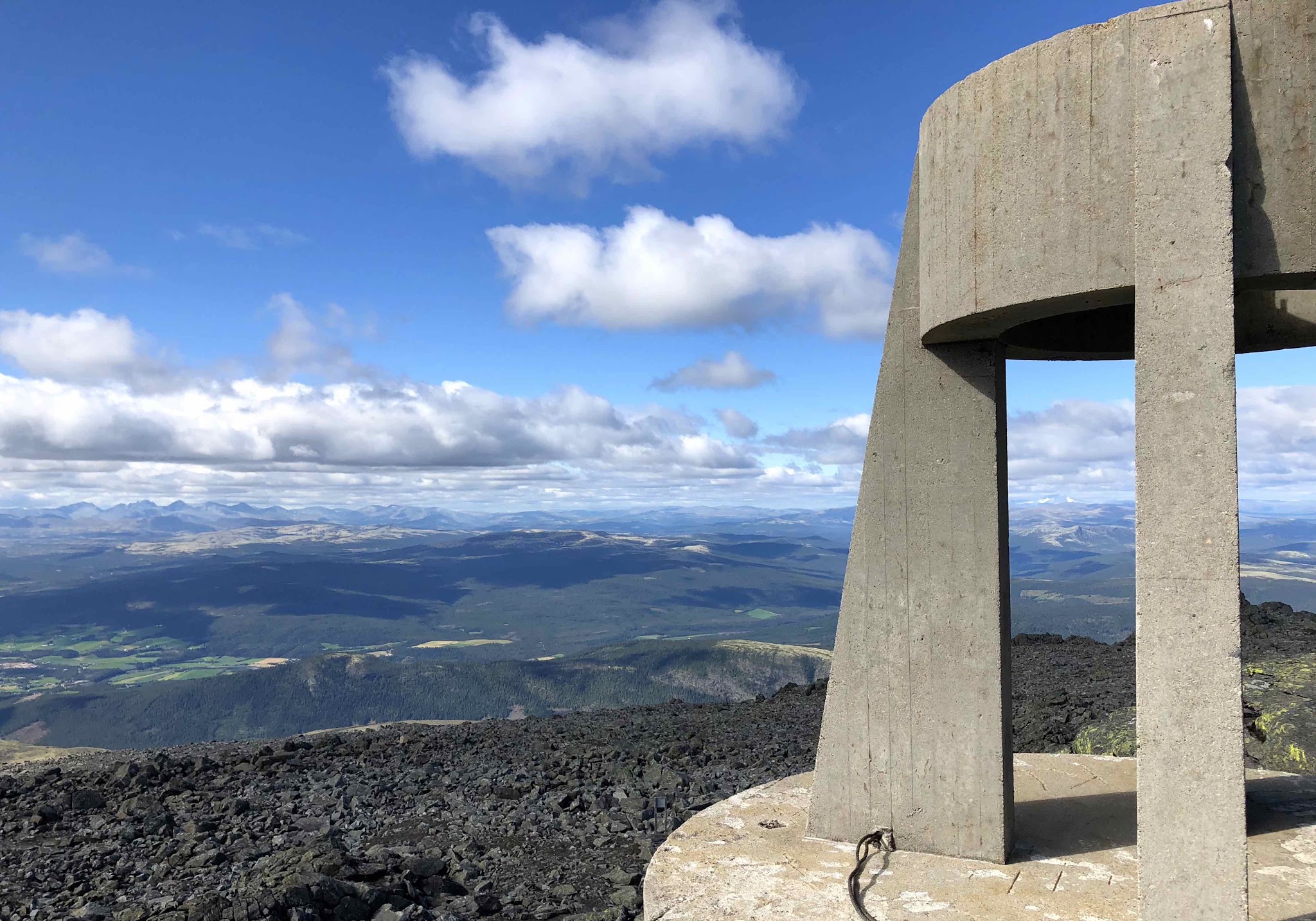 Climbing Tronfjellet - Tron by bike - cement tower and plains below clouds