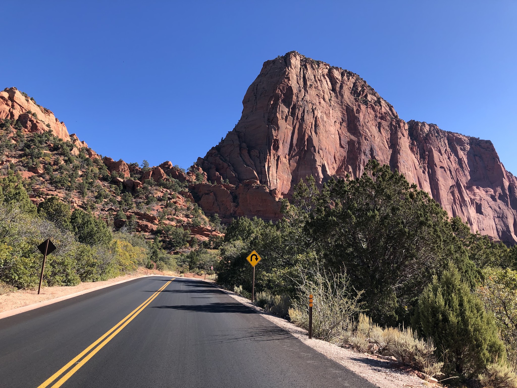 Climbing Kolob Canyon Road by bike - Tayler Hockett and John Johnson with bikes and red rock formations in background