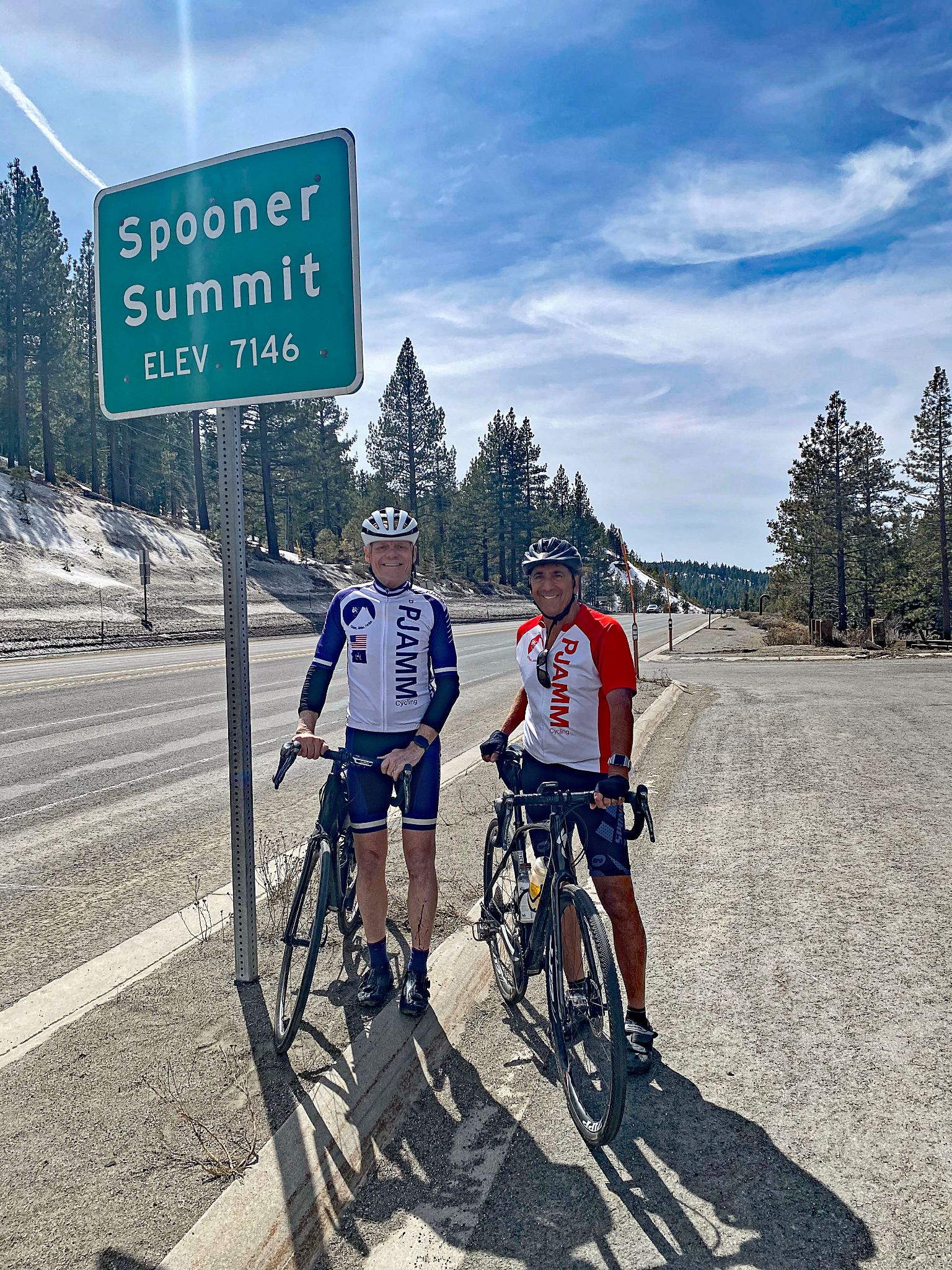Cycling Old Clear Creek Road, NV - PJAMM Cyclists stand with bikes next to road sign for Spooner Summit, Elevation 7146