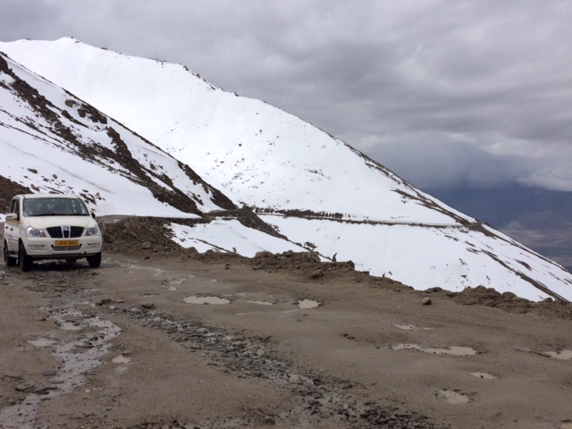Bike climb Khardung La Pass - road, car, snow