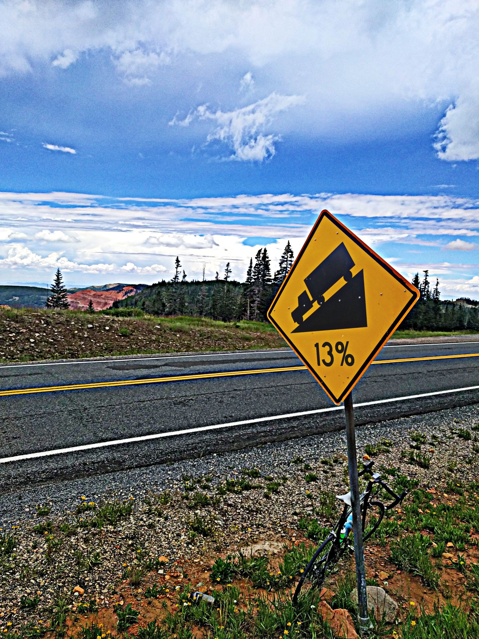 Cycling Bryce Canyon National Park, Utah - bike parked against road sign for 13% grade